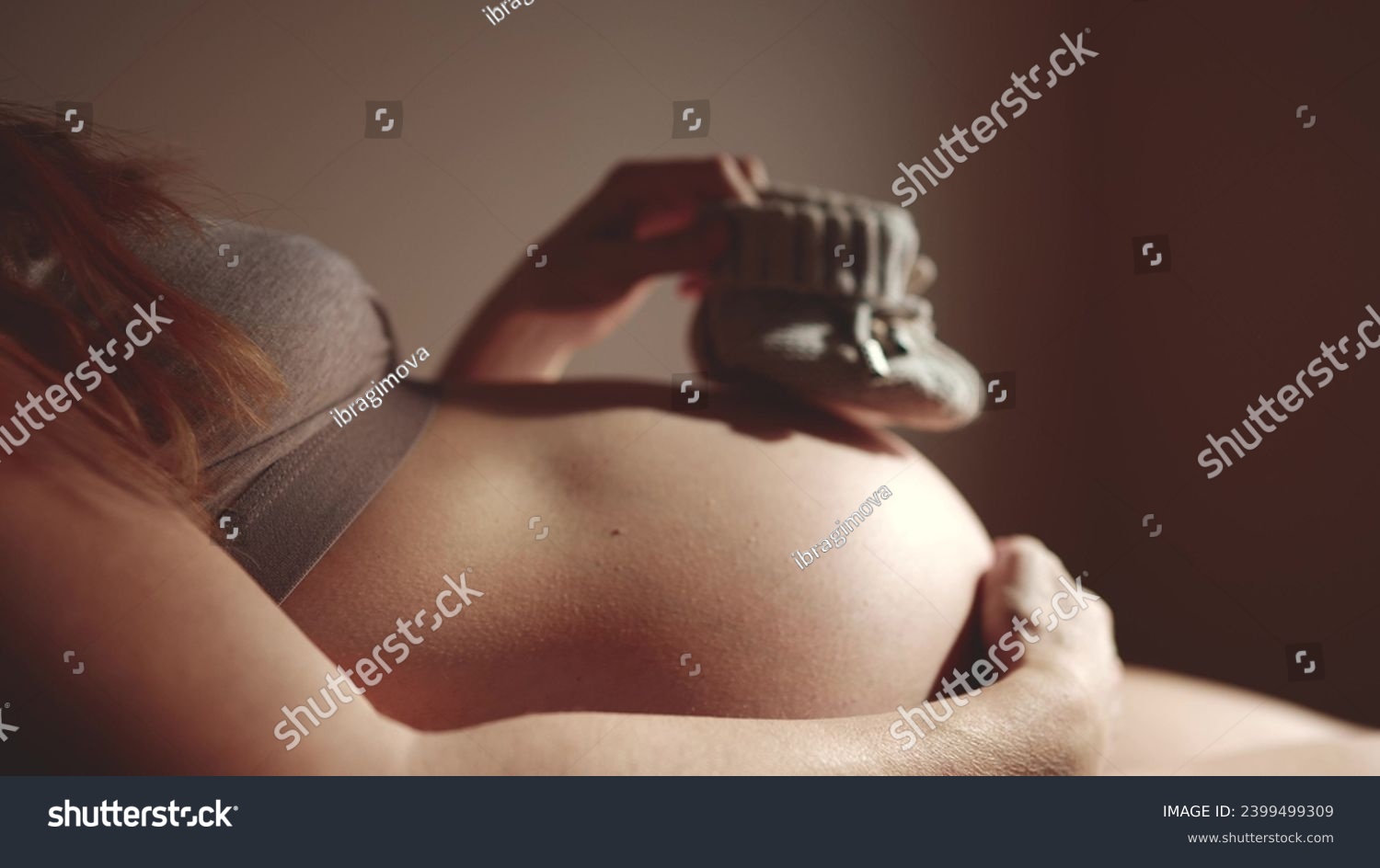 happy pregnant woman. booties baby shoes on the belly of lifestyle a pregnant woman. pregnancy health procreation concept. close-up belly of a pregnant woman. woman waiting for a newborn baby #2399499309