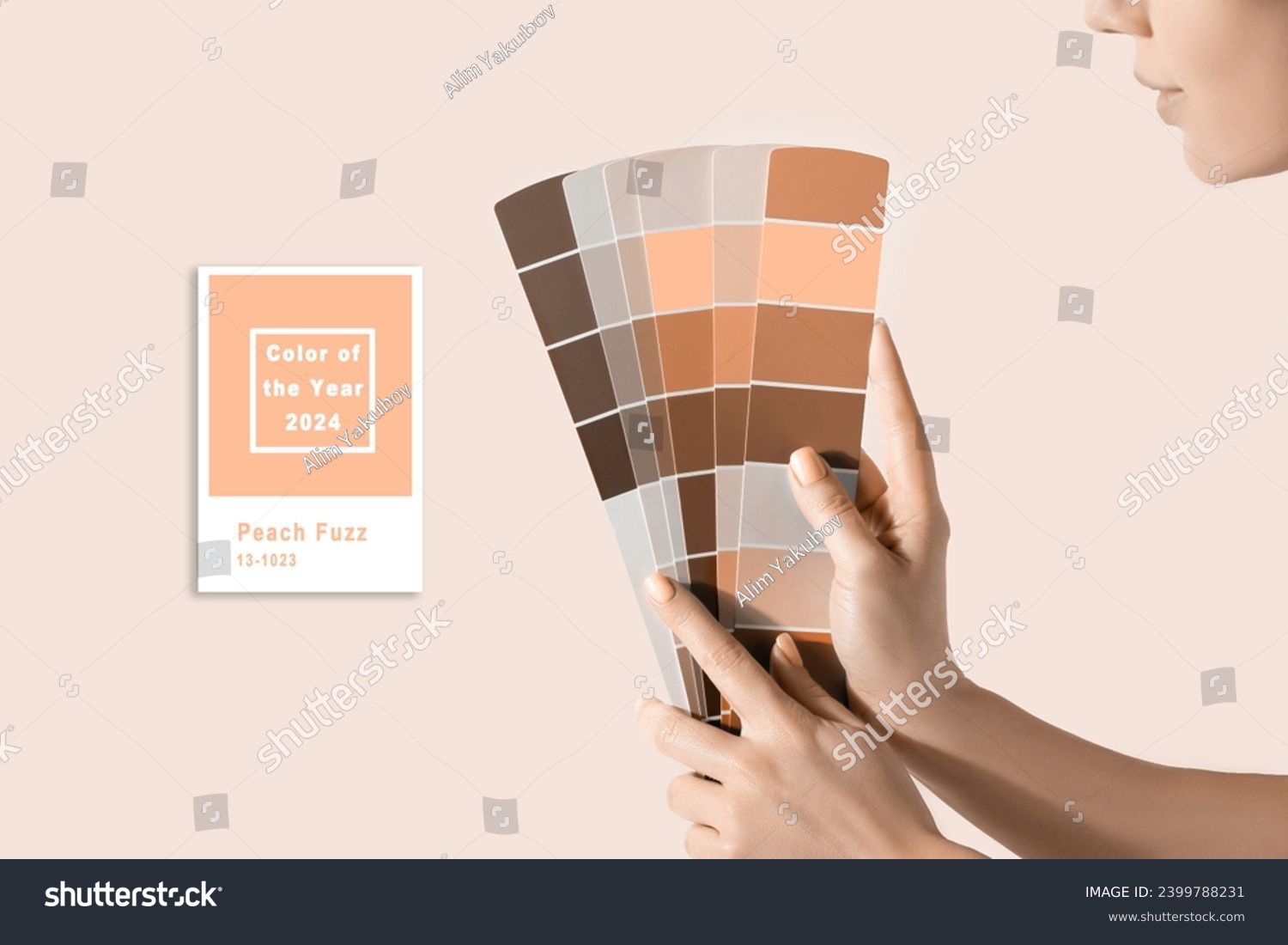 Hand holding Color samples palette design catalog. New trending PANTONE Peach Fuzz colour of 2024 year #2399788231