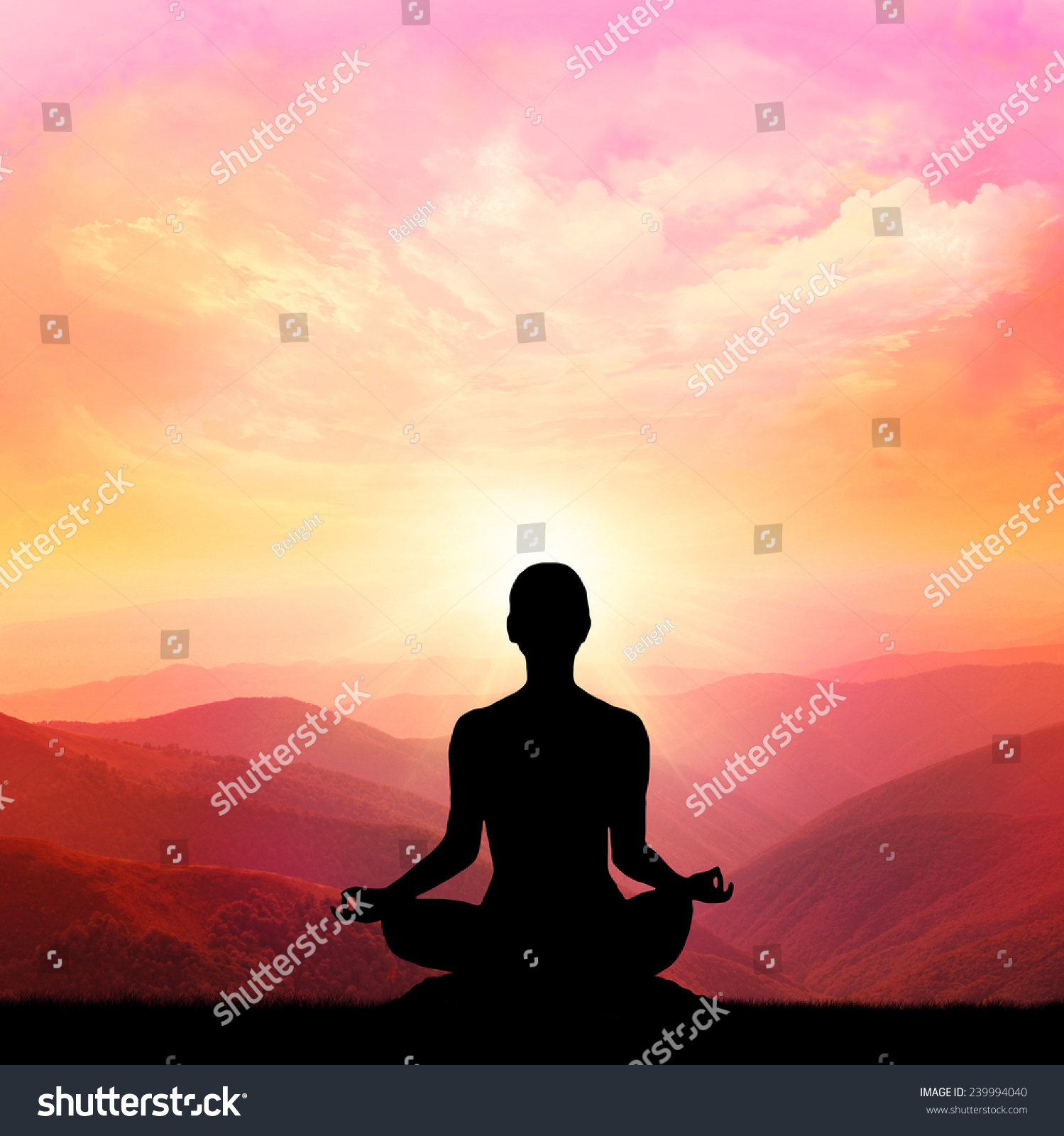 Yoga silhouette on the mountain in the rays of the dawn sun #239994040