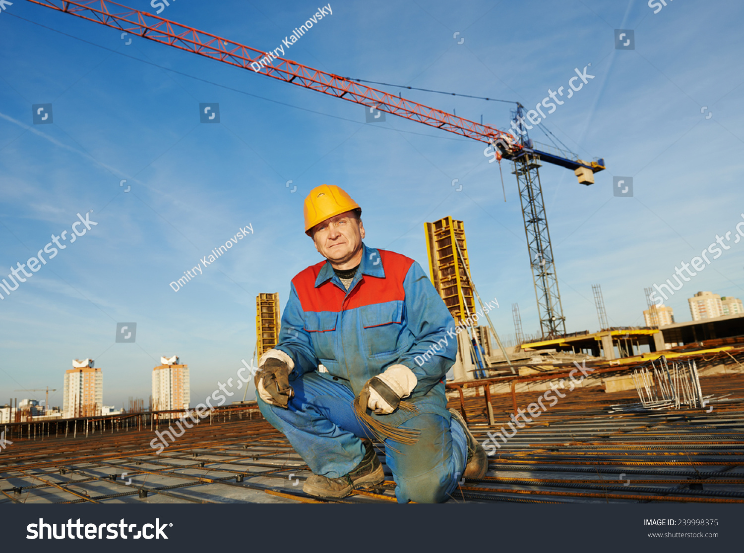 builder worker knitting metal rebars into framework reinforcement for concrete pouring at construction site #239998375