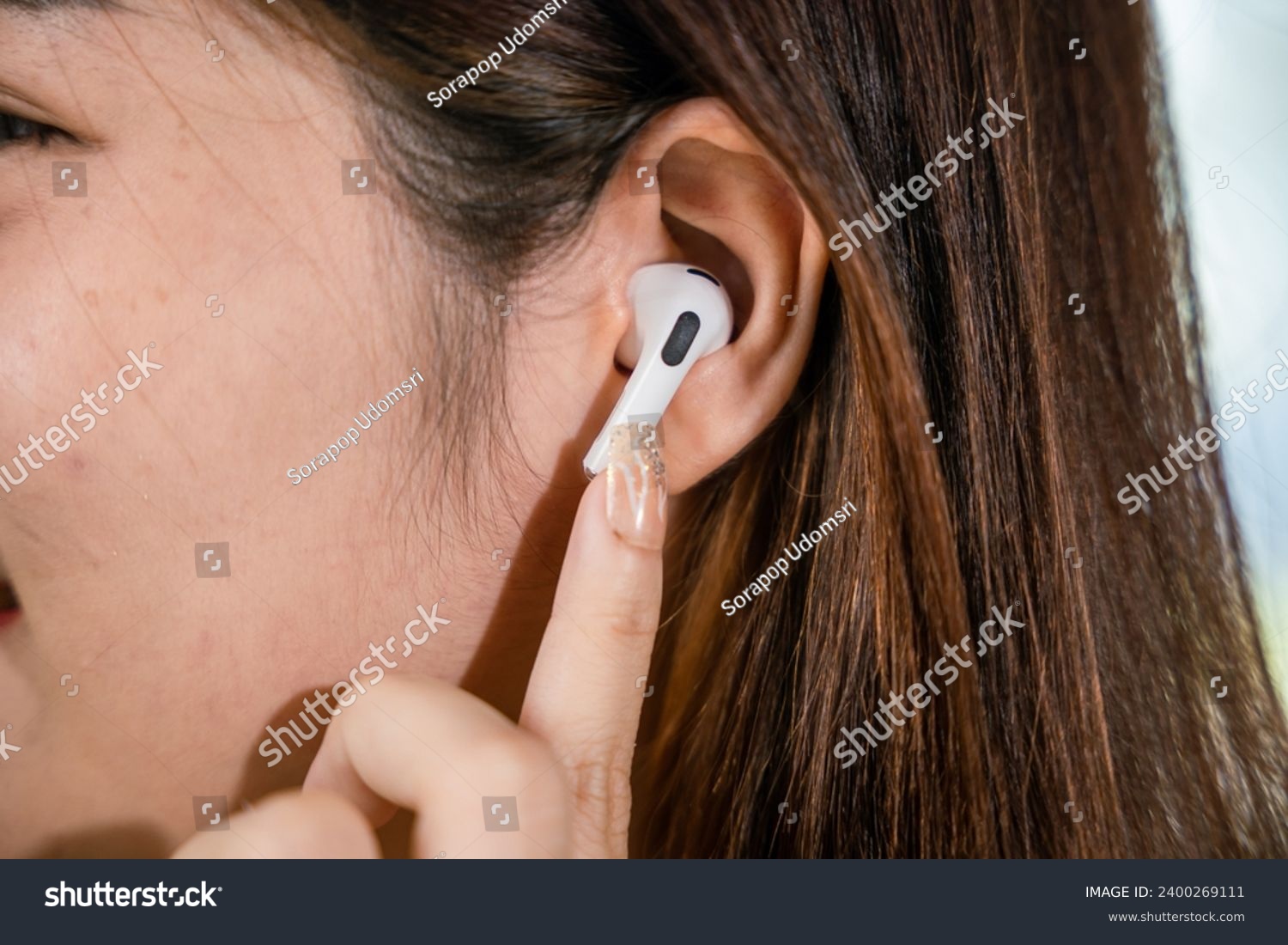 Close up of Happy female touching earbuds to control next listen song on mobile phone in living room at home, Lifestyle woman wearing wireless earphones listening to favorite song on her smartphone #2400269111