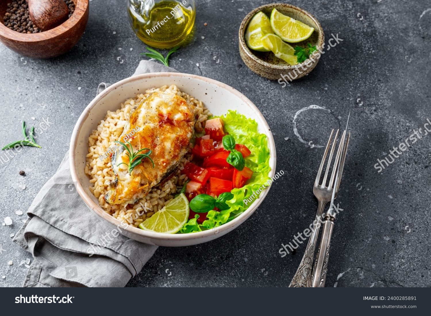 Fried catfish steak with rice and vegetable salad on a gray background. High quality photo #2400285891