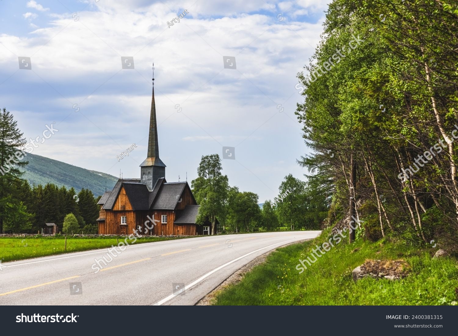 A scenic road winds towards the ancient Kvikne kirke in Innlandet, Norway, a wooden church with a tall spire, gracefully encircled by green trees, depicting a serene and historic tableau #2400381315