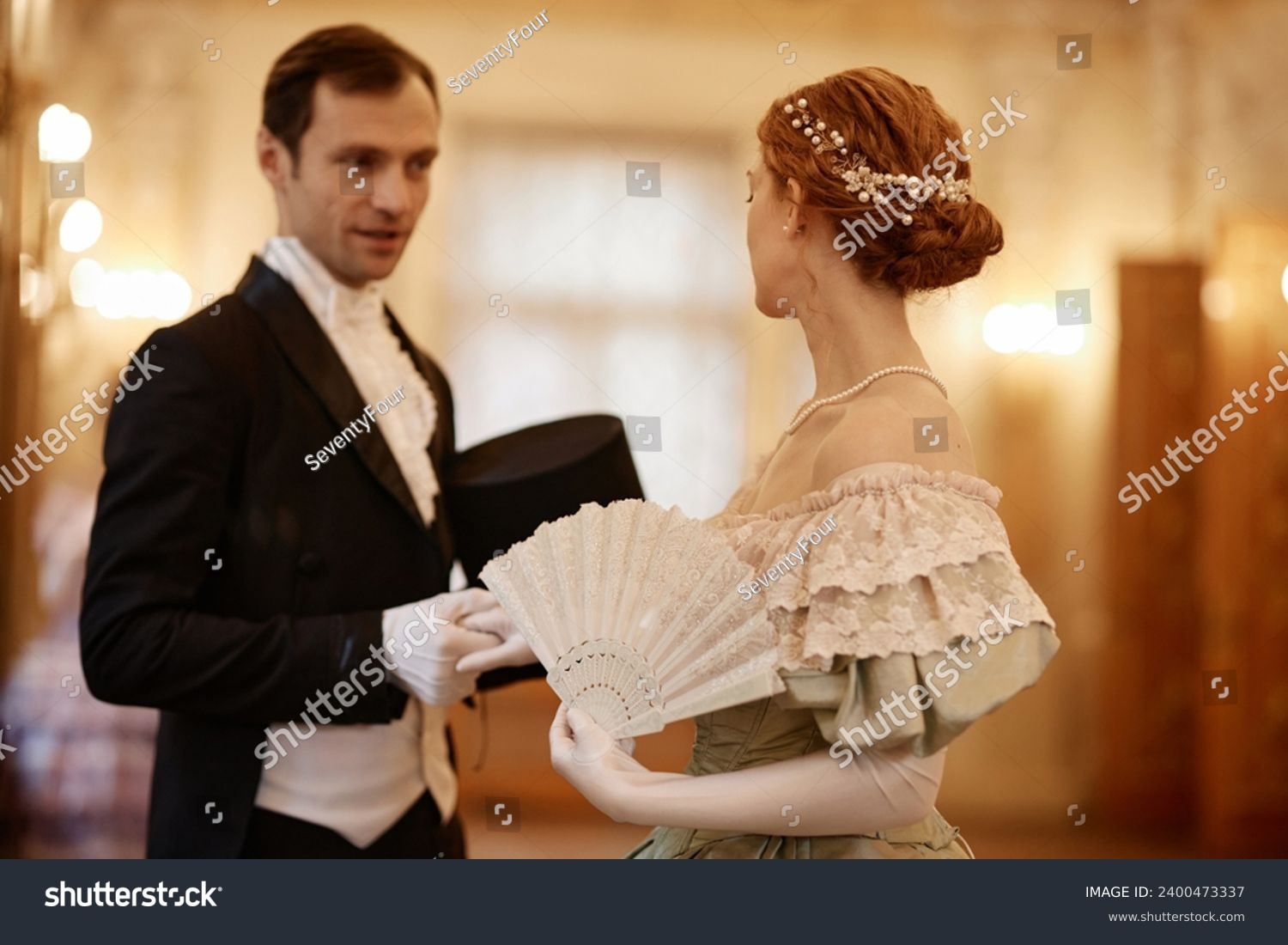 Waist up portrait of elegant couple of lady and gentleman talking in palace hall, copy space #2400473337