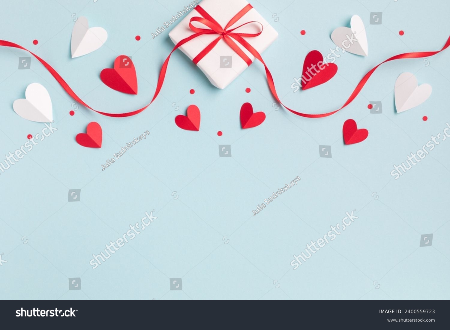 Valentine or mother day festive composition with gift or present box and red hearts on pastel blue background top view. Flat lay style. #2400559723