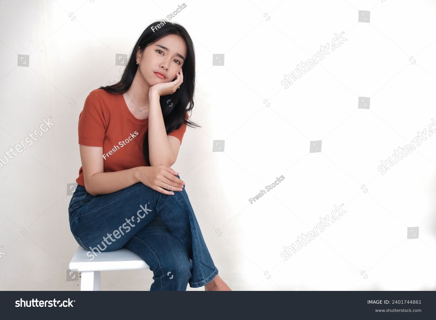 Bored looking Asian woman sitting alone on high stool waiting for someone #2401744861