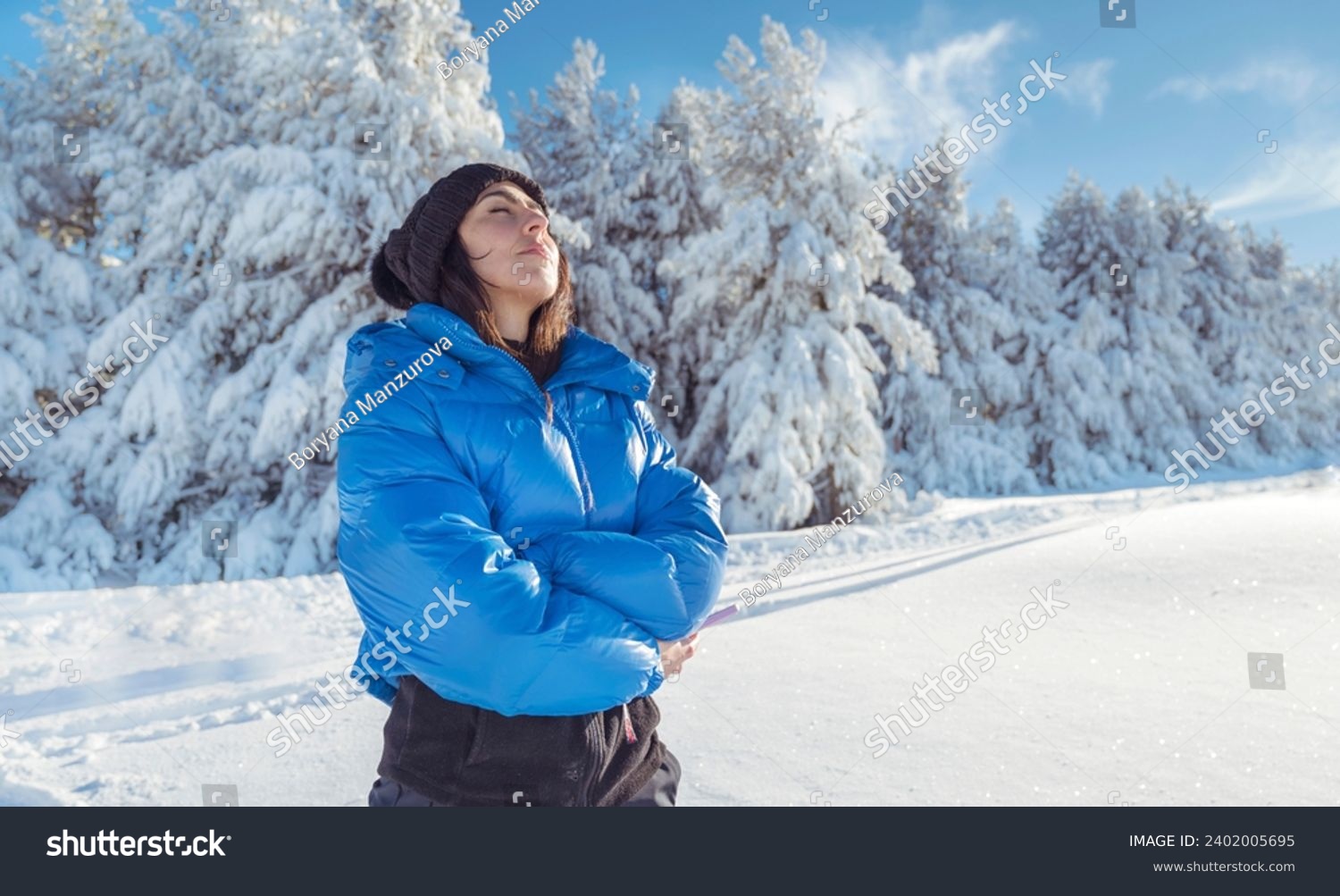 Relaxed woman breathing fresh air in a snowy winter mountain . Winter time #2402005695