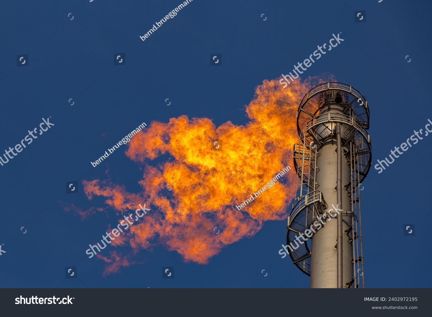 Flare of a coking plant with blue sky #2402972195