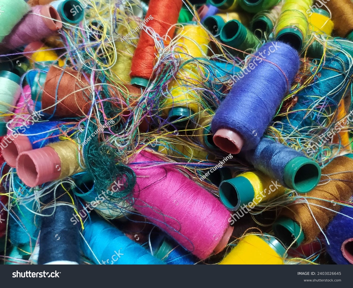 Chaotic pile of colorful sewing threads stock photo. #2403026645