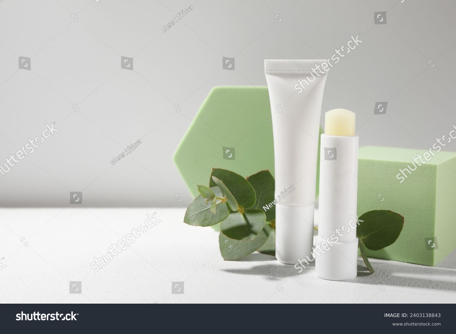Stylish presentation of different lip balms on white table, space for text #2403138843