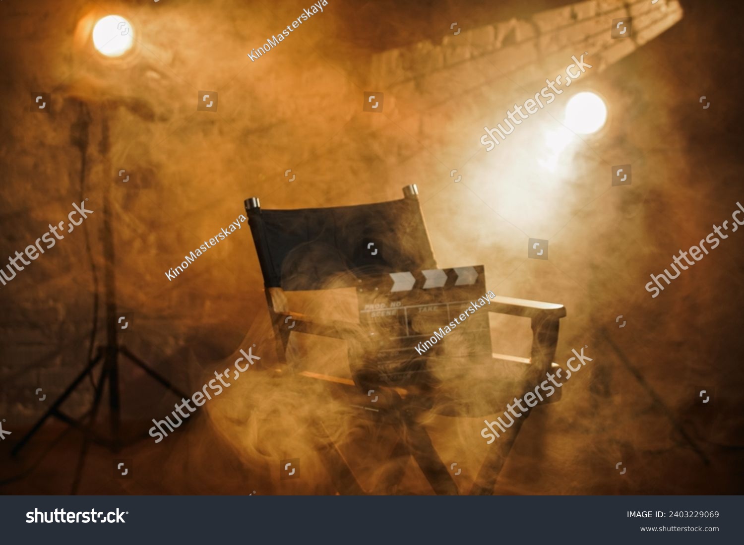 Close up shot of cinema clapperboard standing on director's chair, spotlights at the background, warm light and smoke in the scene. #2403229069
