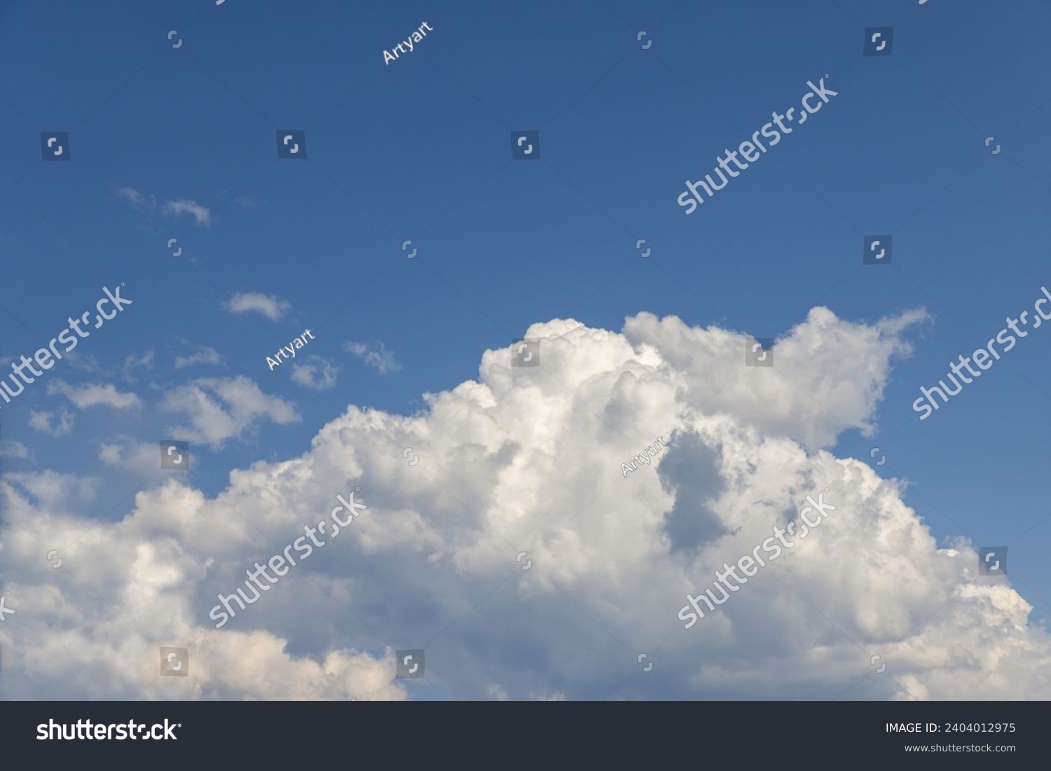 A large, pure white cumulus cloud, resembling a colossal mountain, set against the backdrop of a clear blue sky #2404012975