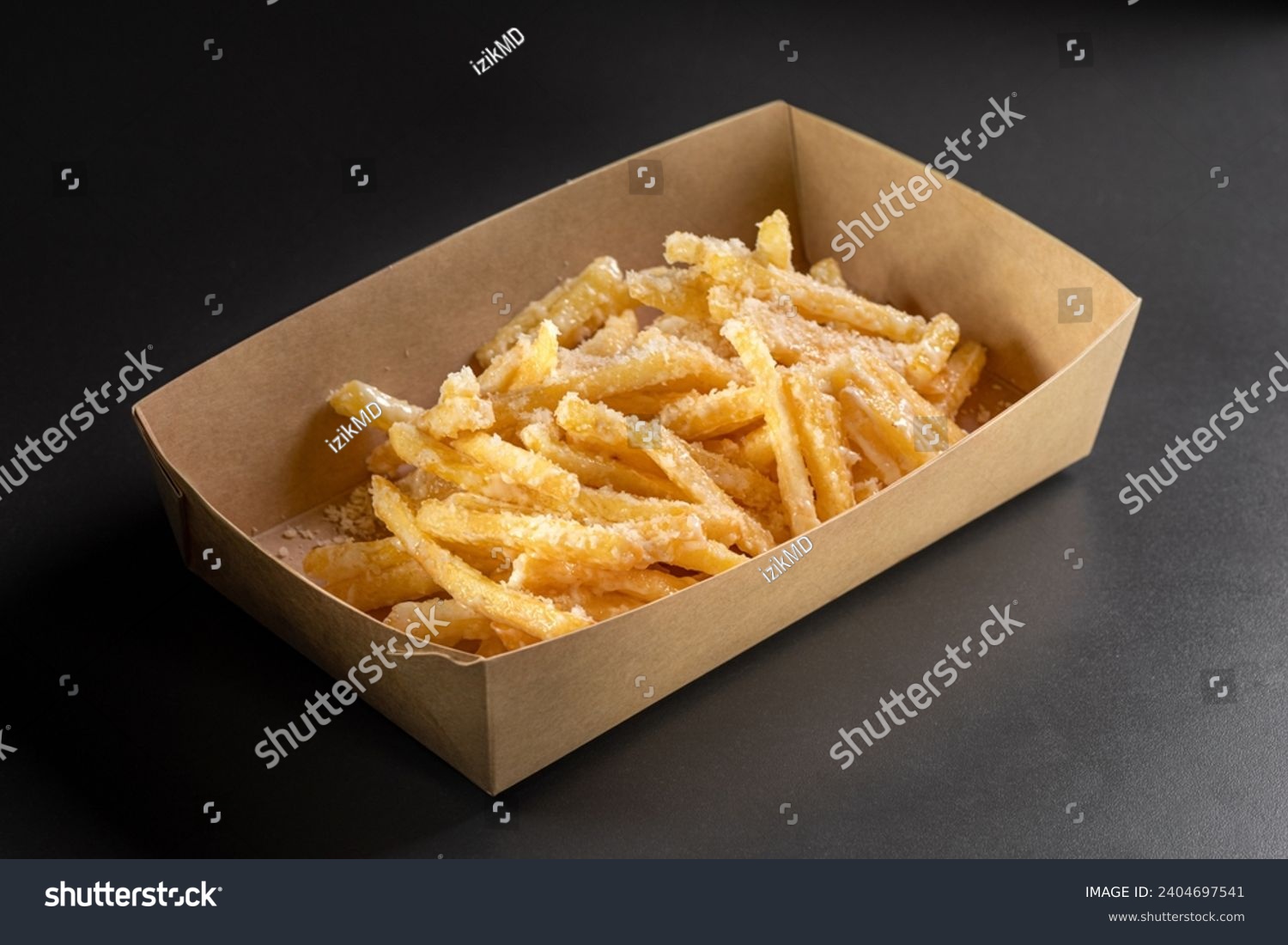 Delicious, tasty french fries topping with Parmesan cheese on top on a black background, in a container for delivery. Deep fry potato or appetizer, fast food. Dish of crisp golden potato chips. #2404697541