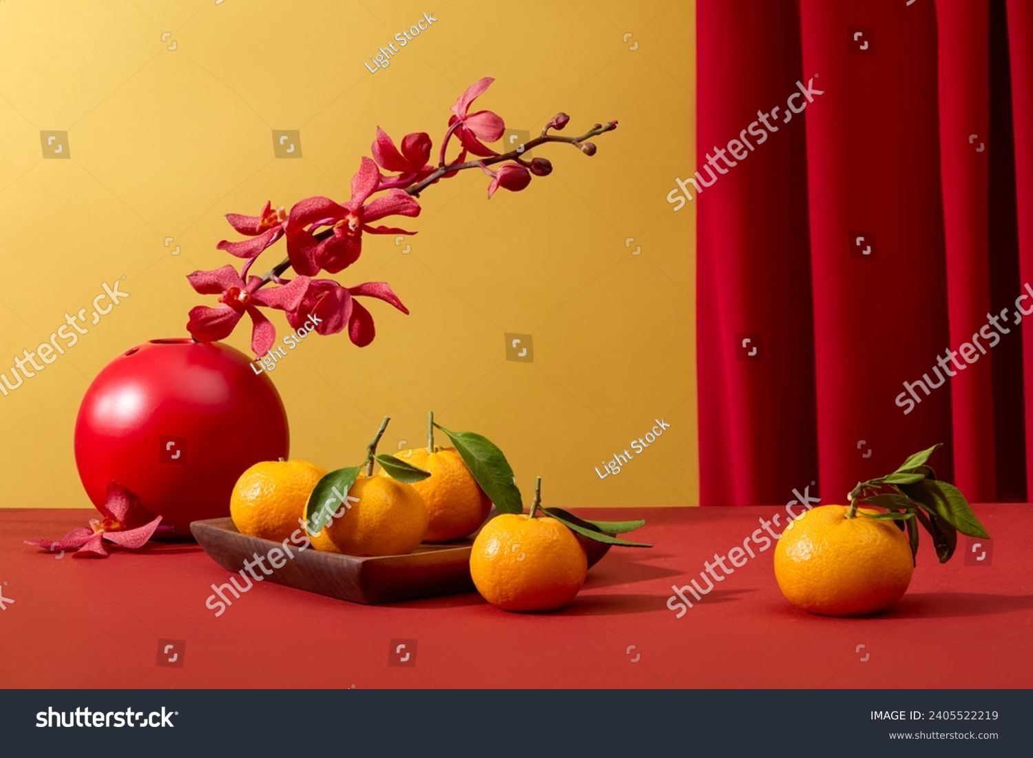Tangerines displayed on wooden dish and a flower pot decorated on red surface. During Chinese New Year, red is said to symbolize luck and happiness #2405522219