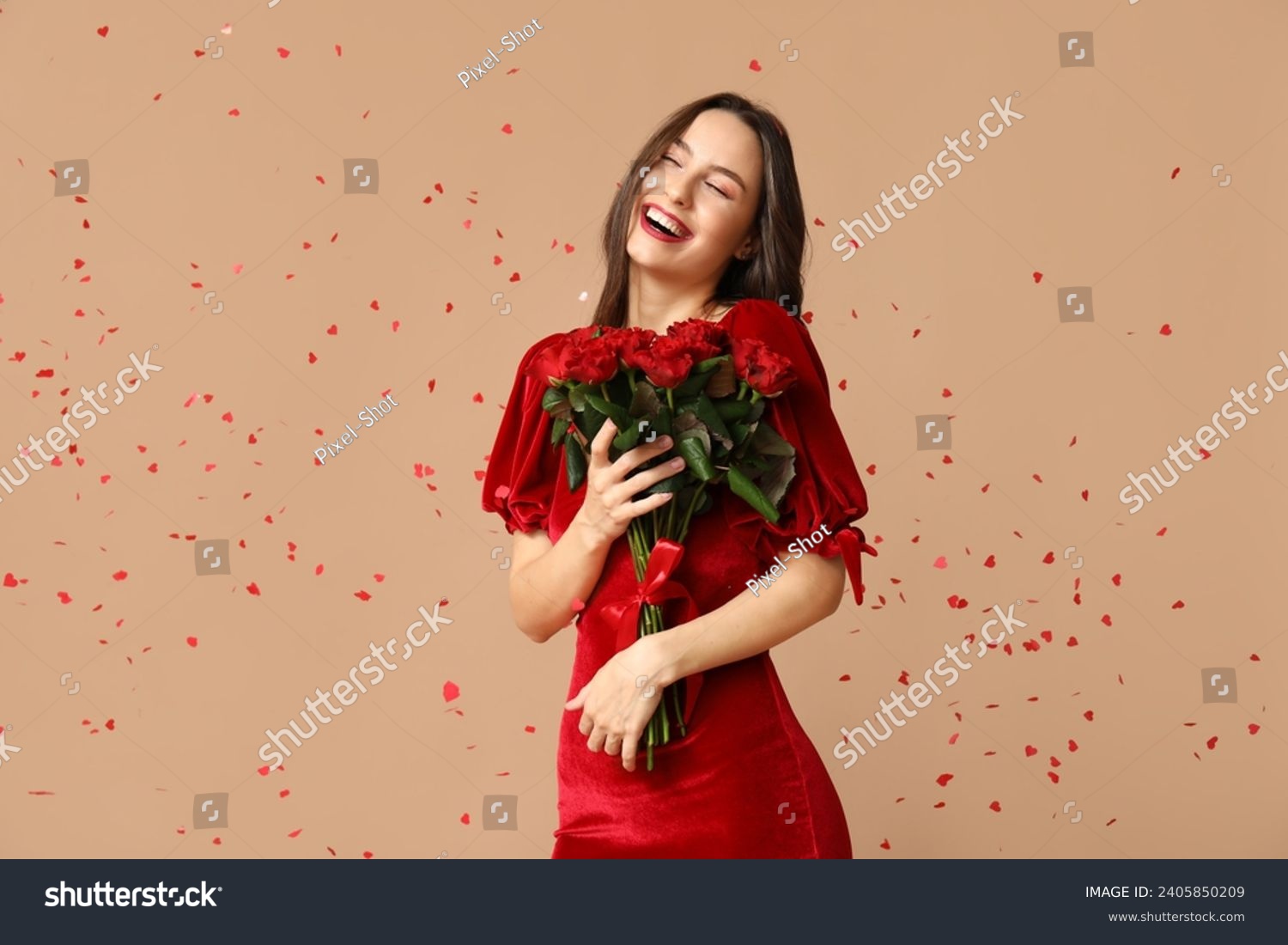 Beautiful young woman with bouquet of red roses and confetti on brown background. Valentine's Day celebration #2405850209