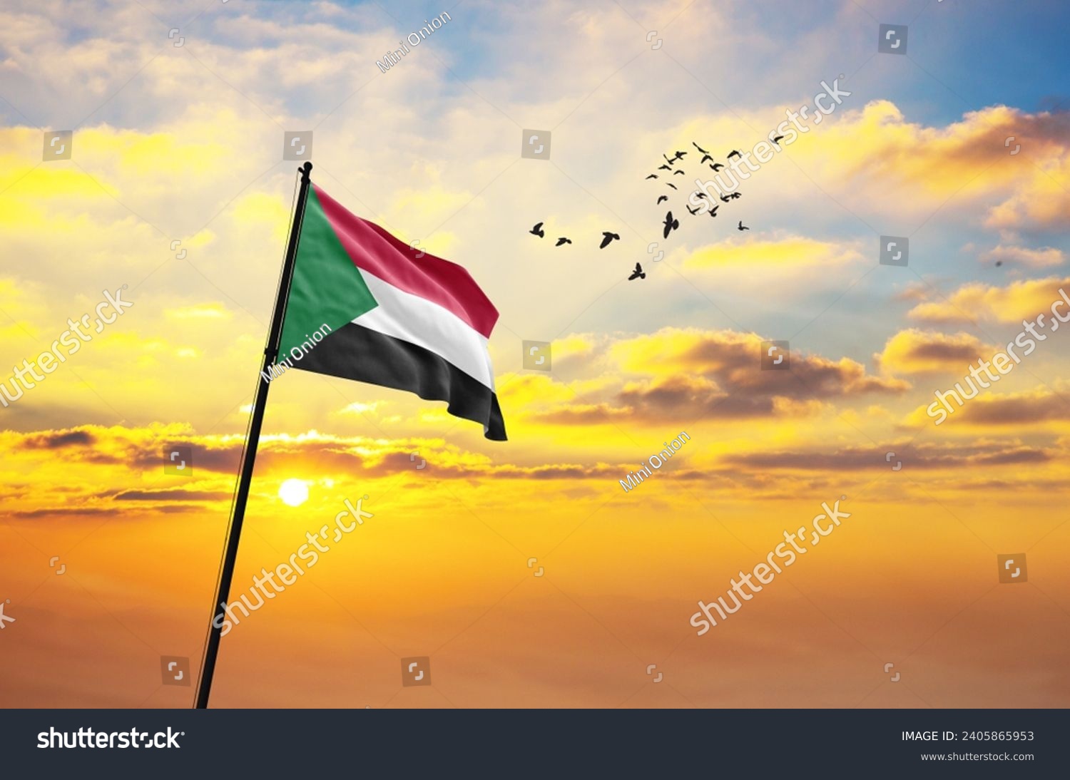 Waving flag of Sudan against the background of a sunset or sunrise. Sudan flag for Independence Day. The symbol of the state on wavy fabric. #2405865953