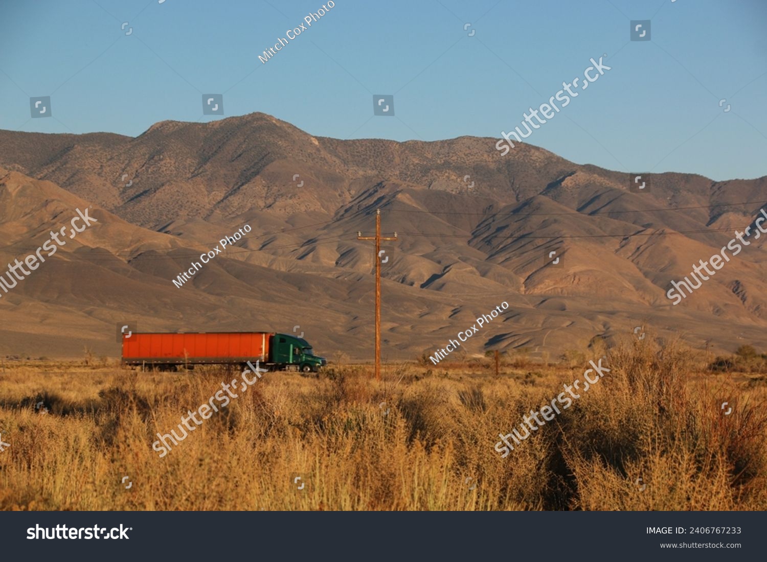 A big rig truck hauls goods across the desert #2406767233