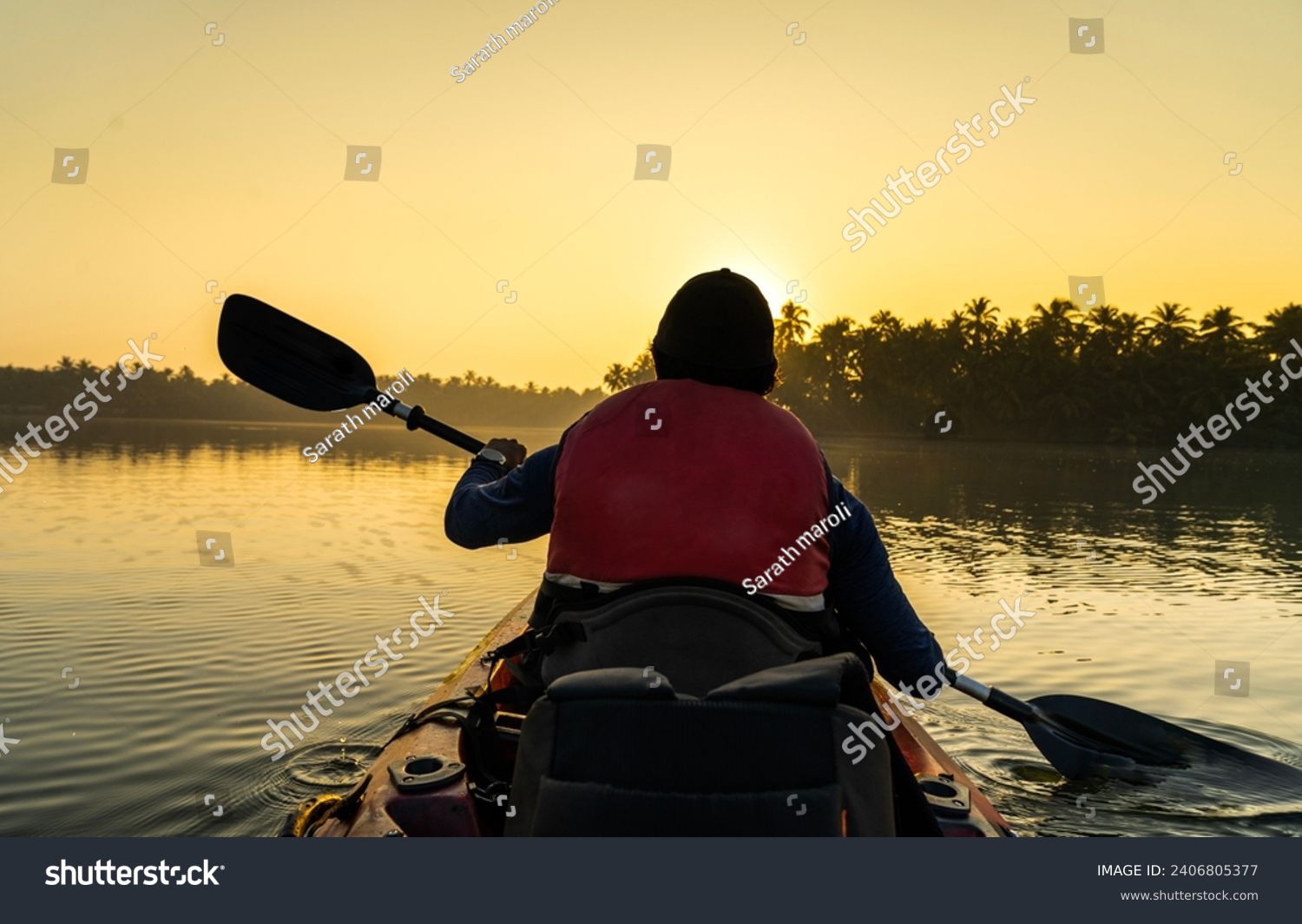 Kayaking on the river during sunrise, young man canoeing in Kavvayi Island Kannur, Kerala backwaters adventure activities  #2406805377