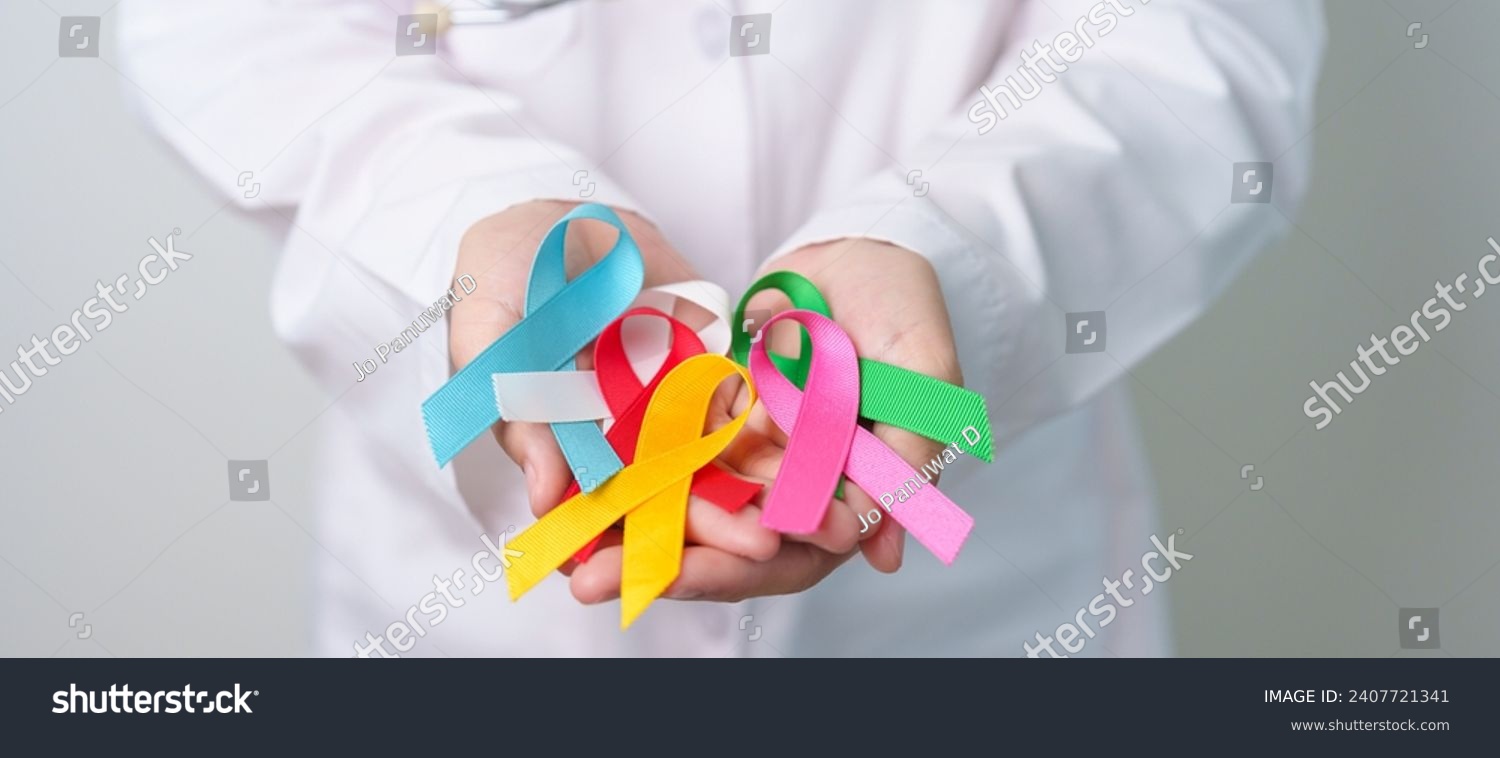World cancer day, February 4. Doctor holding blue, red, green, white, pink, blue and yellow ribbons for supporting people living and illness. Healthcare and Autism awareness day concept #2407721341