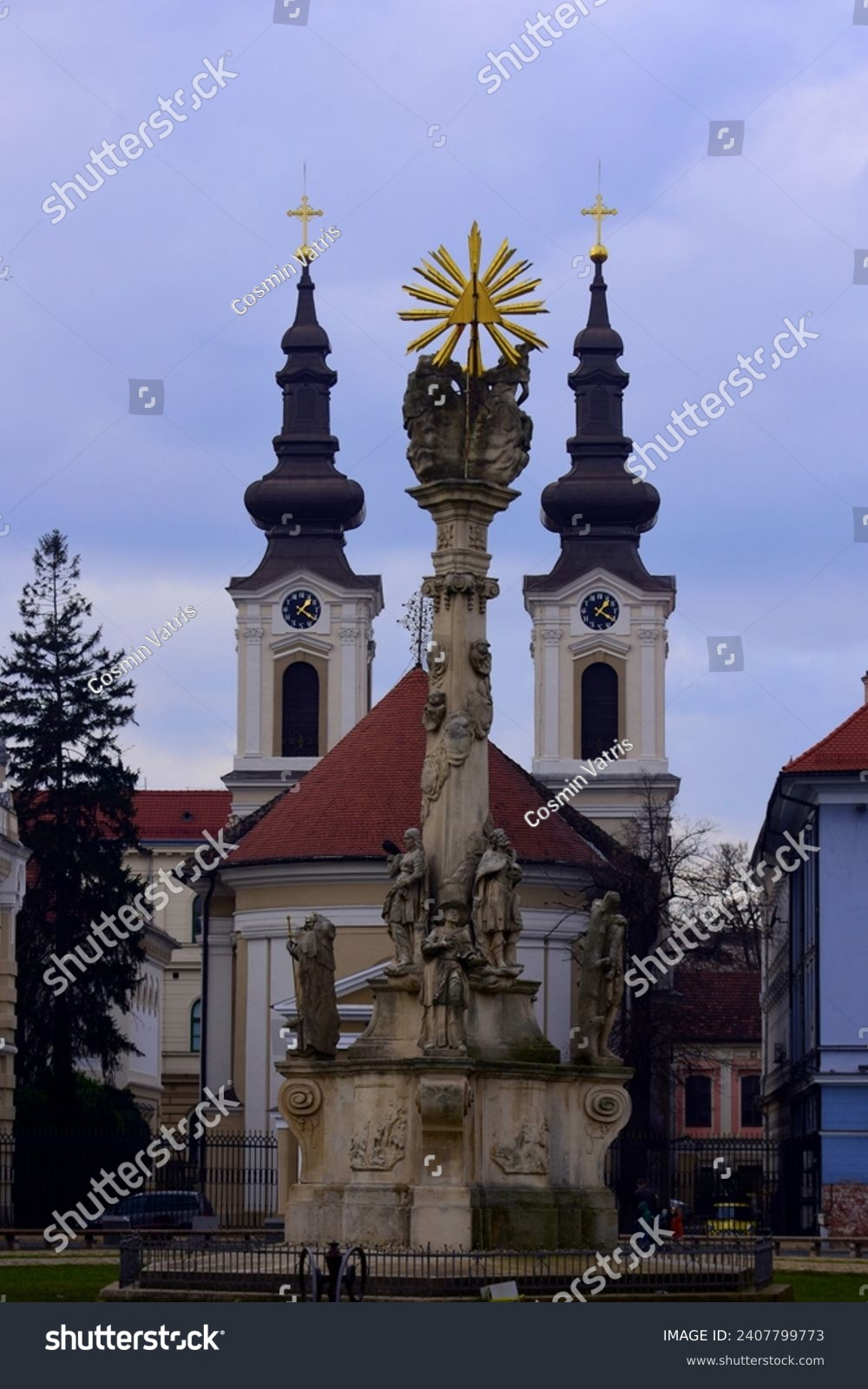 Urban image from Timisoara, Romania. The Plague Statue or Holy Trinity Statue is framed by the towers of the Serbian Church. #2407799773