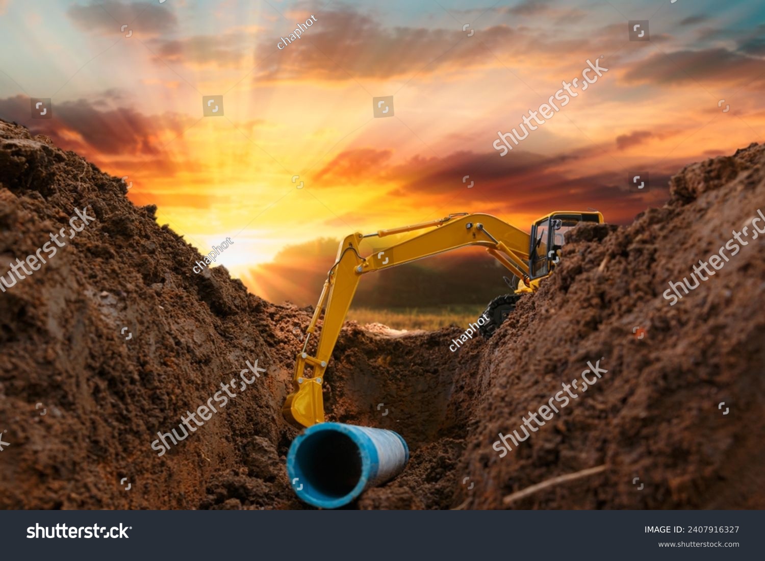 Crawler excavator is digging in the construction site pipeline work on sunset sky background #2407916327