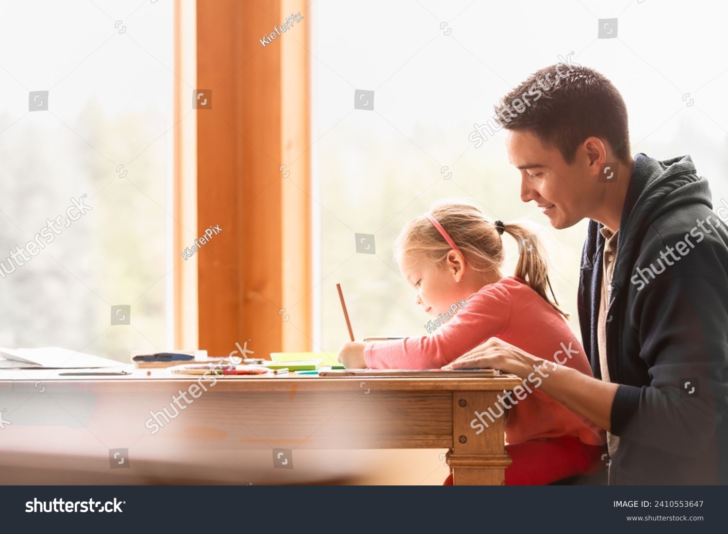 Happy young father and child at home learning writing doing homework  #2410553647
