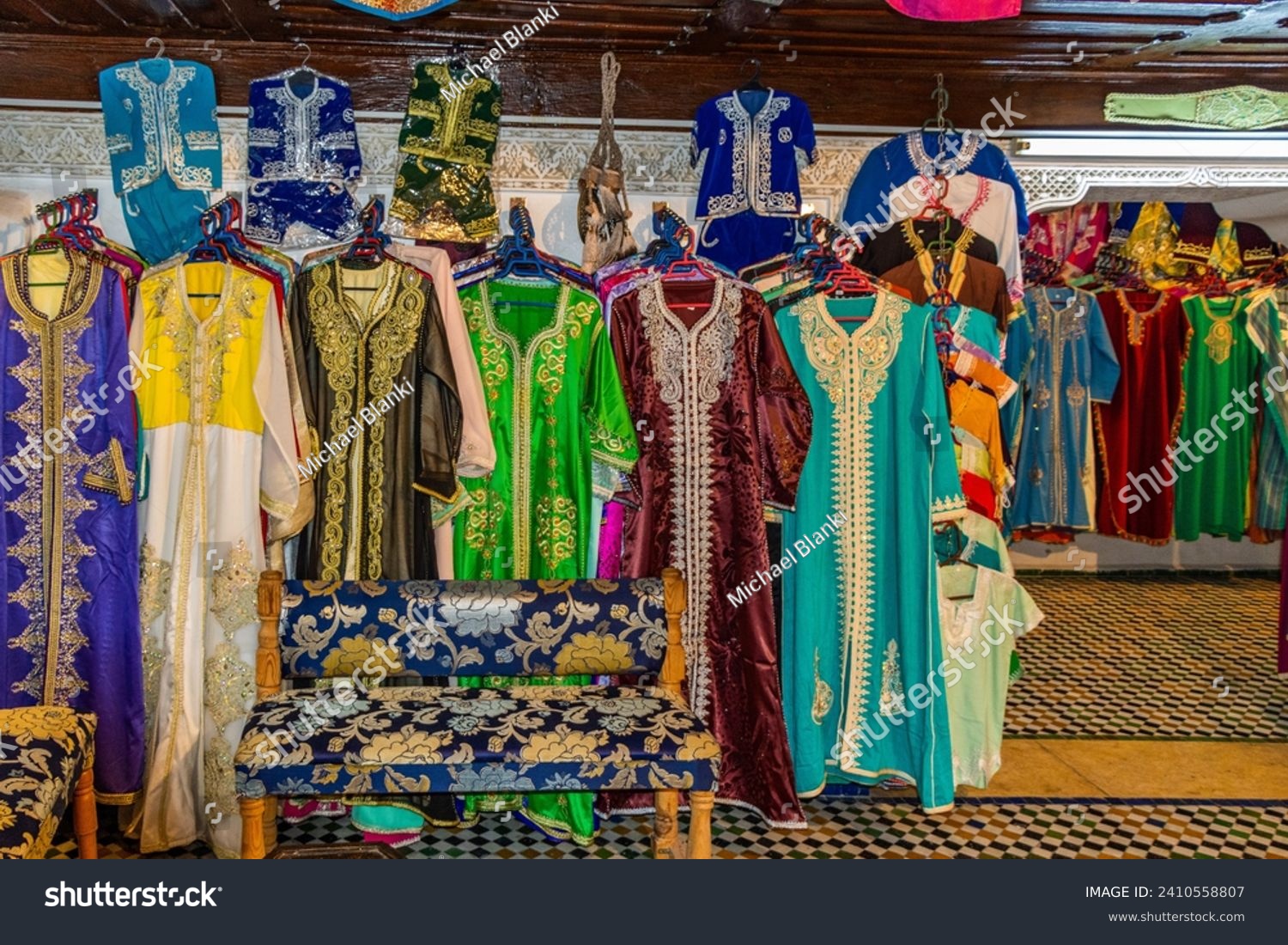 Morocco, row of typical colourful womens embroidered djellaba tunics for sale #2410558807