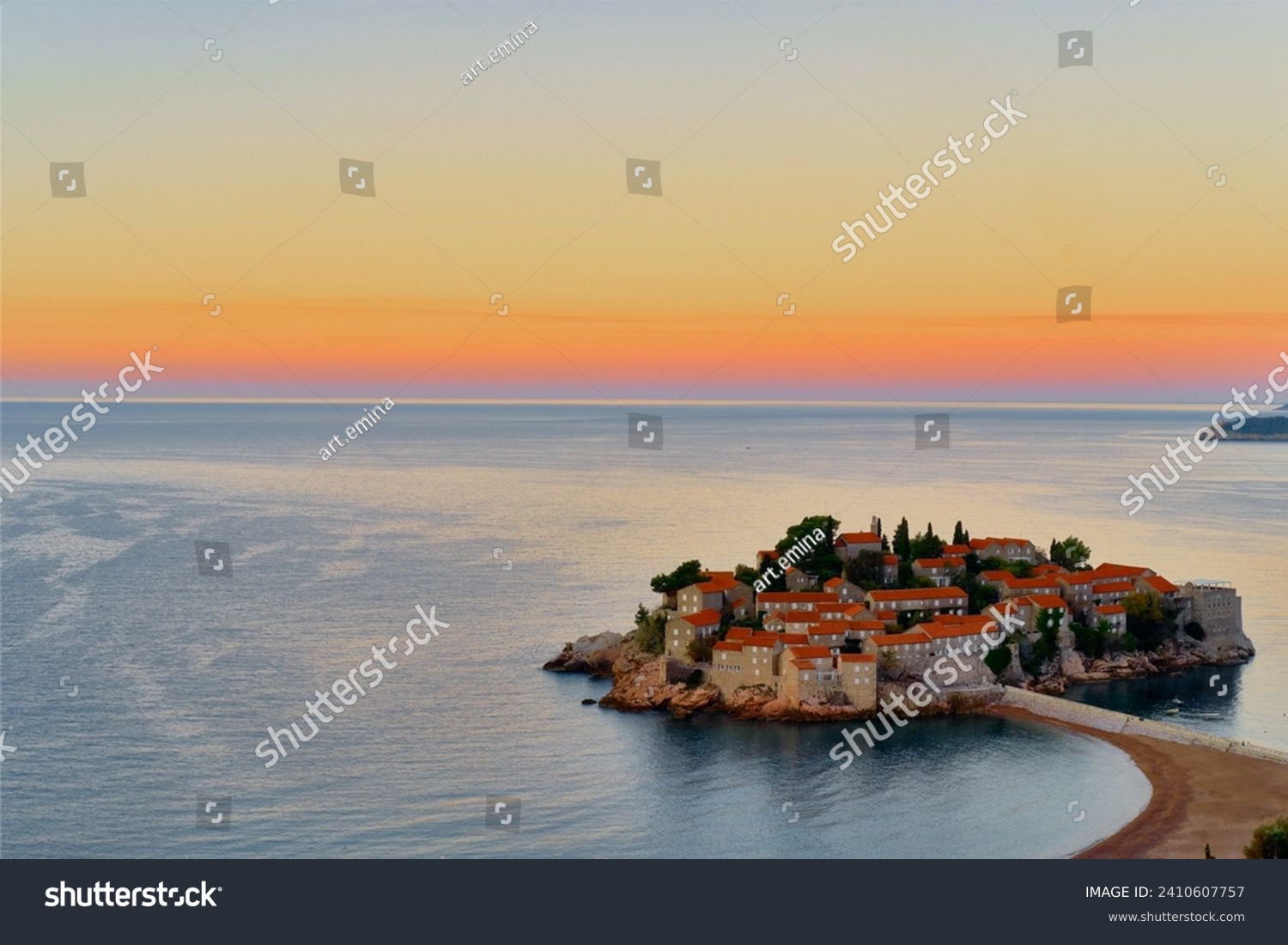 Sveti Stefan at sunset. Deserted winter beach. Colorful sky reflecting in the Adriatic sea and old stone houses. #2410607757
