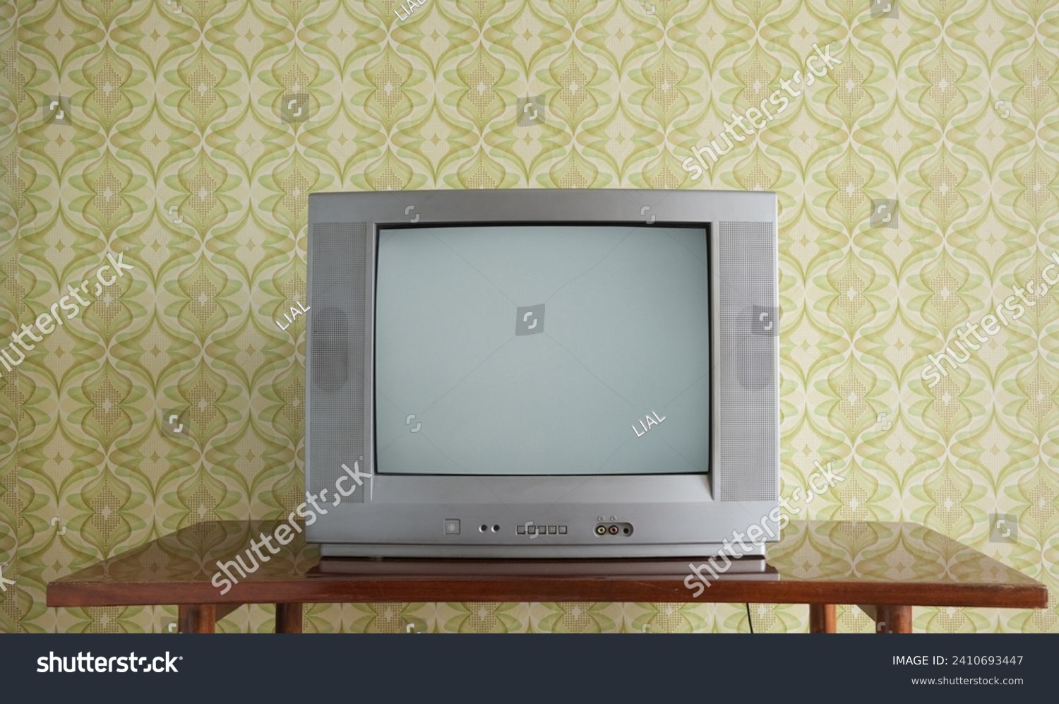 Old TV on the nightstand against the background of wallpaper. #2410693447