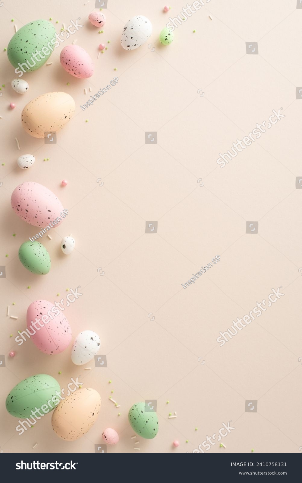 Seasonal Joy Display: Top-view vertical photo showcasing traditional Easter eggs, and scattered colorful sprinkles against a pastel beige backdrop with space for text or ads #2410758131