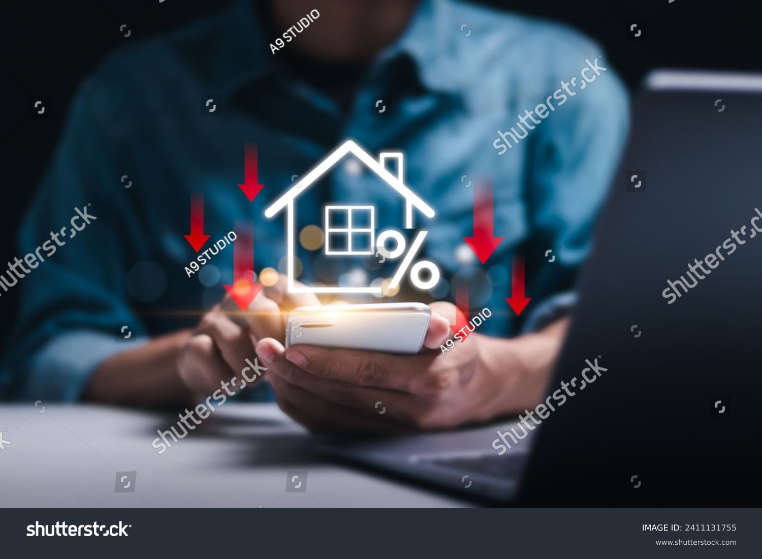 Businessman use smartphone with virtual home icon and down arrow for economical real estate and lower mortgage interest rates. Reduced prices for rental housing, Demand for home purchases decreases. #2411131755
