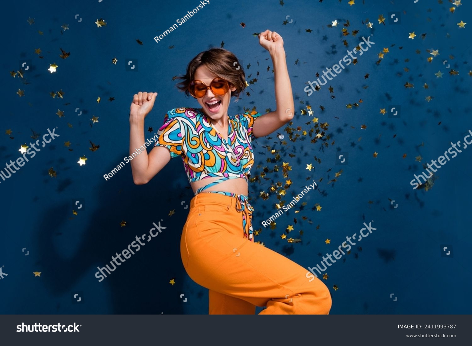 Photo portrait of lovely young lady celebrate victory dancing dressed stylish flared pants garment isolated on dark blue color background #2411993787