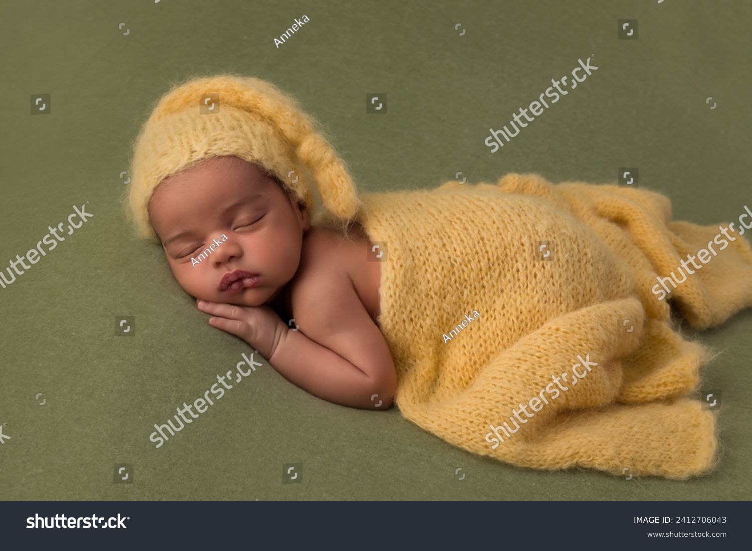 Cute little sleeping African biracial newborn baby sleeping with a knitted yellow hat and wrap #2412706043