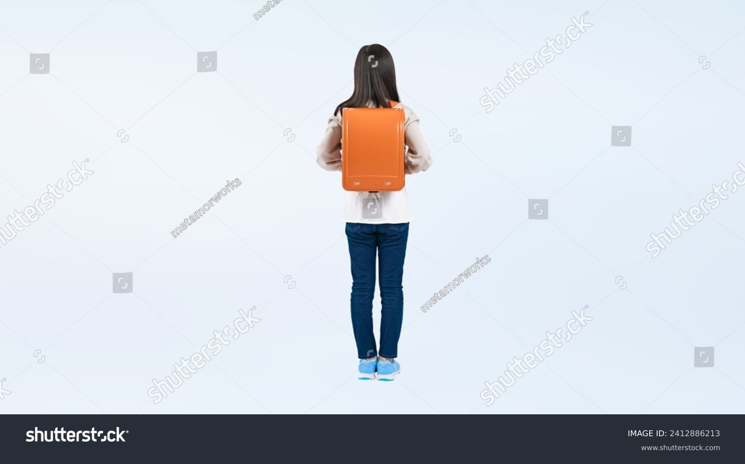 Elementary school girl standing with a school bag on her back. #2412886213