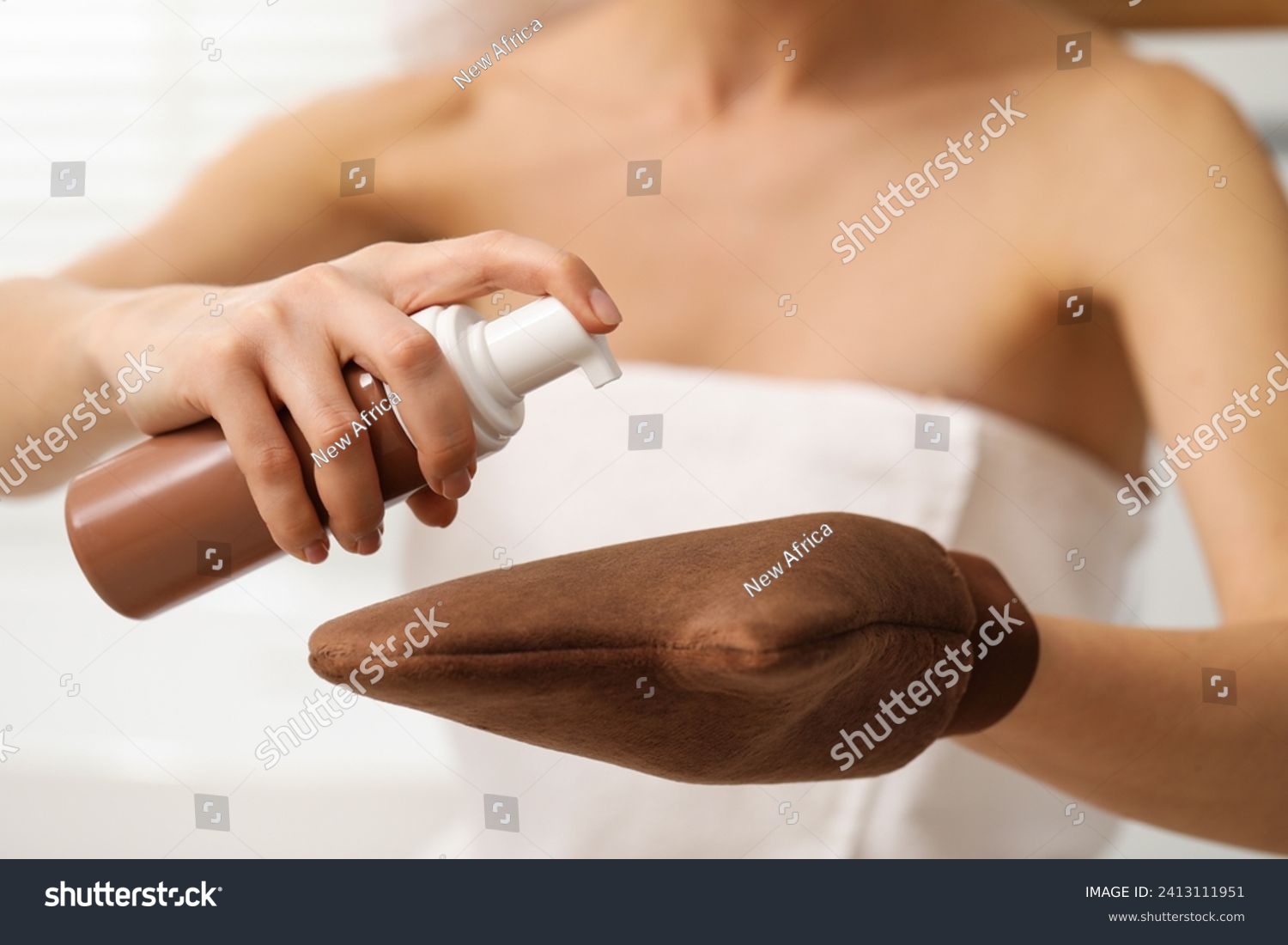 Self-tanning. Woman applying cosmetic product onto tanning mitt indoors, closeup #2413111951