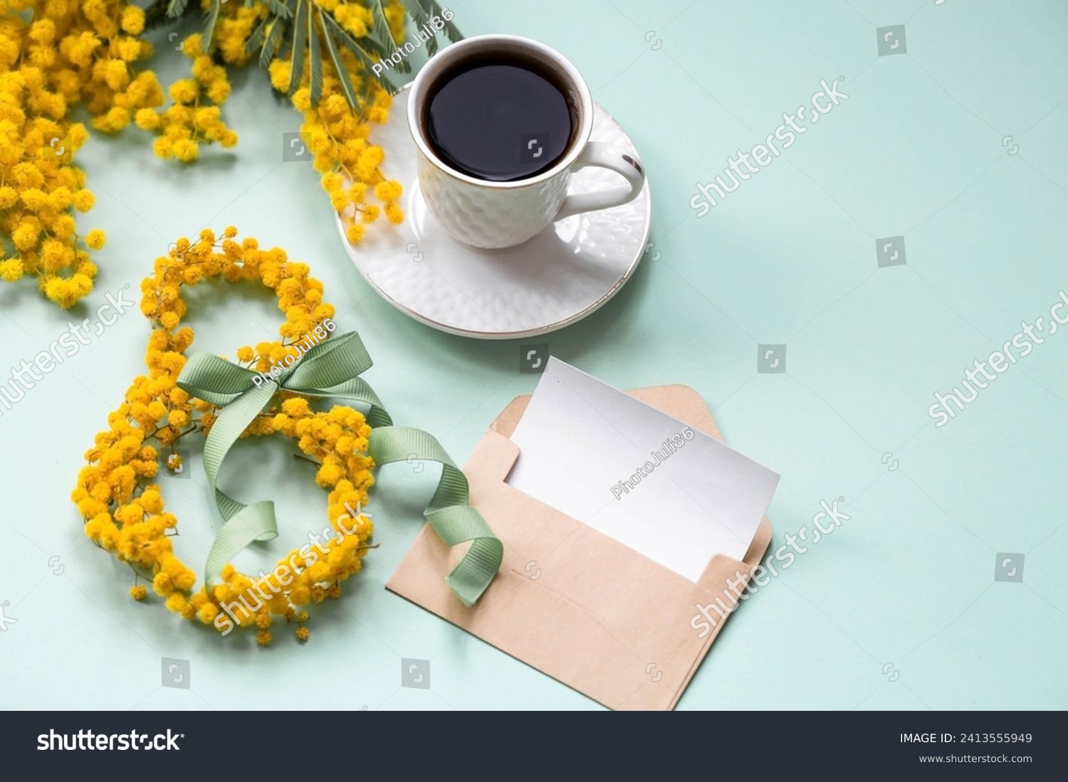 International Women's Day. A banner a beautiful postcard for March 8th. Yellow mimosa flowers in the shape of the number eight, a coffee mug and an envelope with a place for text on a turquoise. #2413555949