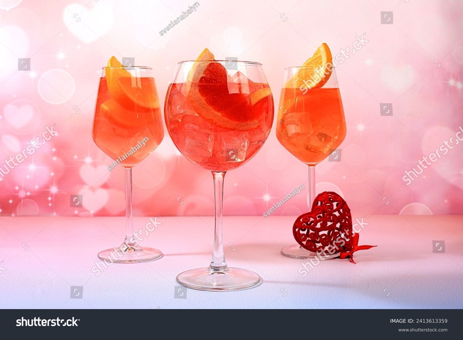 Festive alcoholic cocktail Aperol spritz in glasses and love hearts, bar concept and valentine's day, alcoholic drinks at party, restaurant advertising, selective focus #2413613359