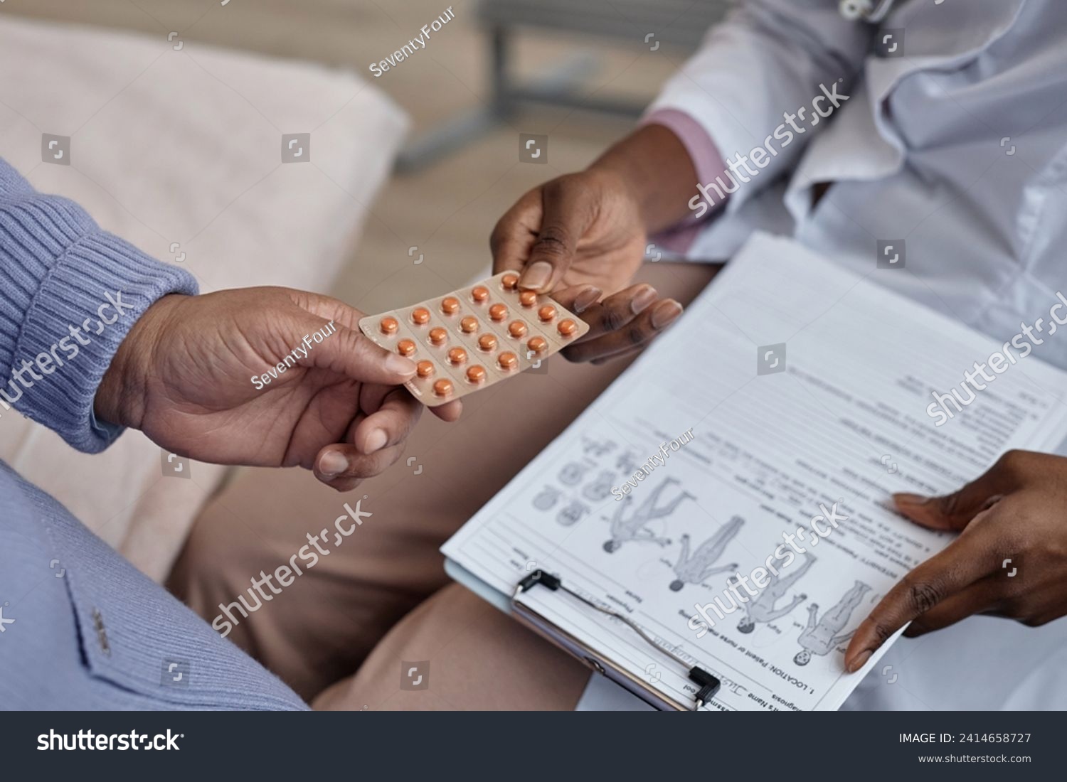 Close up shot unrecognizable doctor giving blister pack of prescribed pills to patient during visit in hospital #2414658727