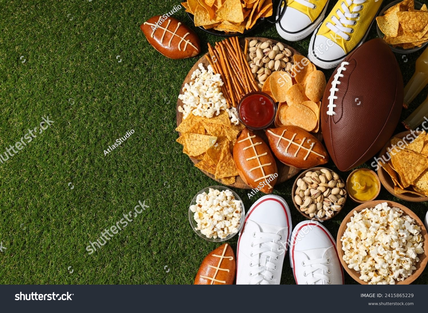 A bowl with various beer snacks and a rugby ball on the grass #2415865229