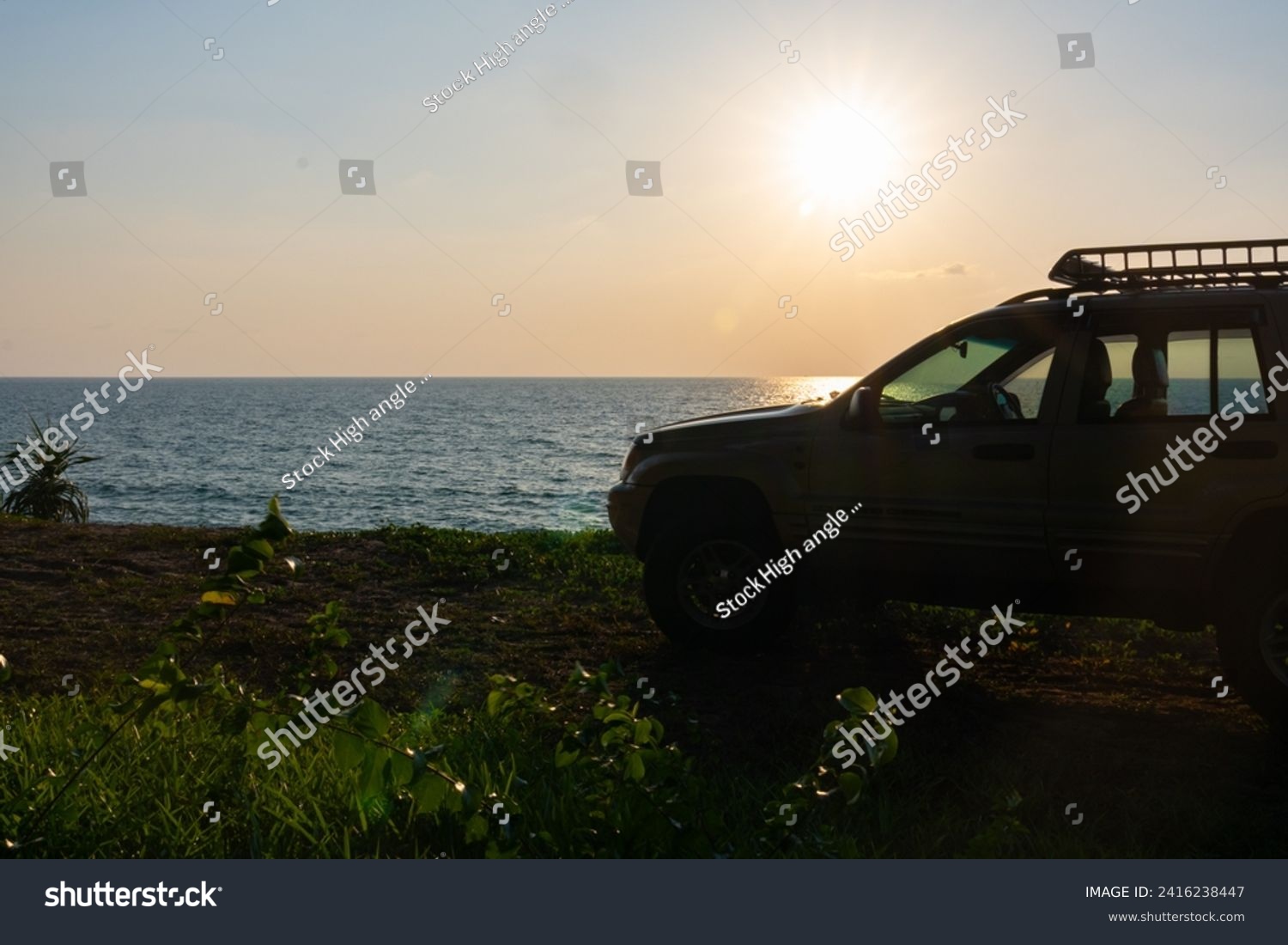 Phuket Thailand January 22,2024:Brown American SUV Jeep Grand Cherokee WJ 2002 on the beach sunset sky background in Phuket island Thailand,Travel and camping concept transportation background #2416238447