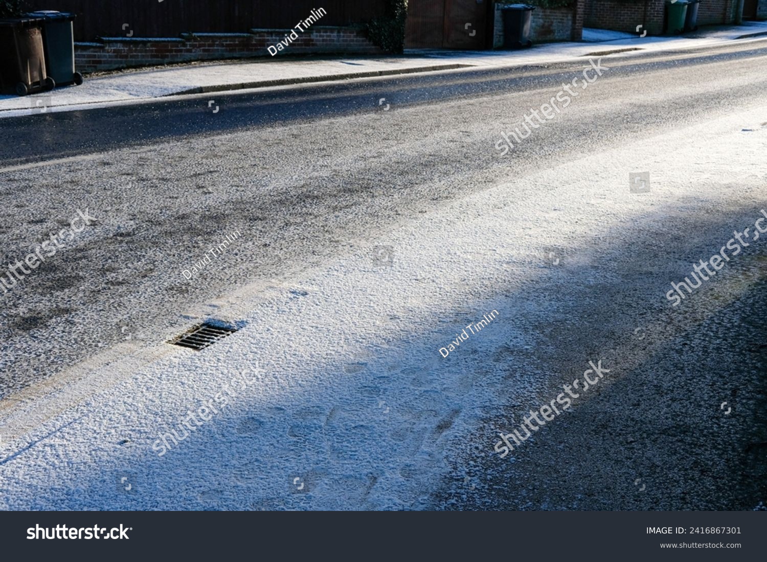Snow settling on a road during winter cold snap  #2416867301