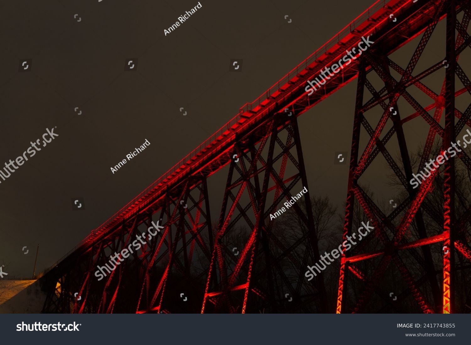 View of the illuminated 1908 railway trestle bridge seen from Chaudière boulevard during a winter evening, Cap-Rouge area, Quebec City, Quebec, Canada #2417743855