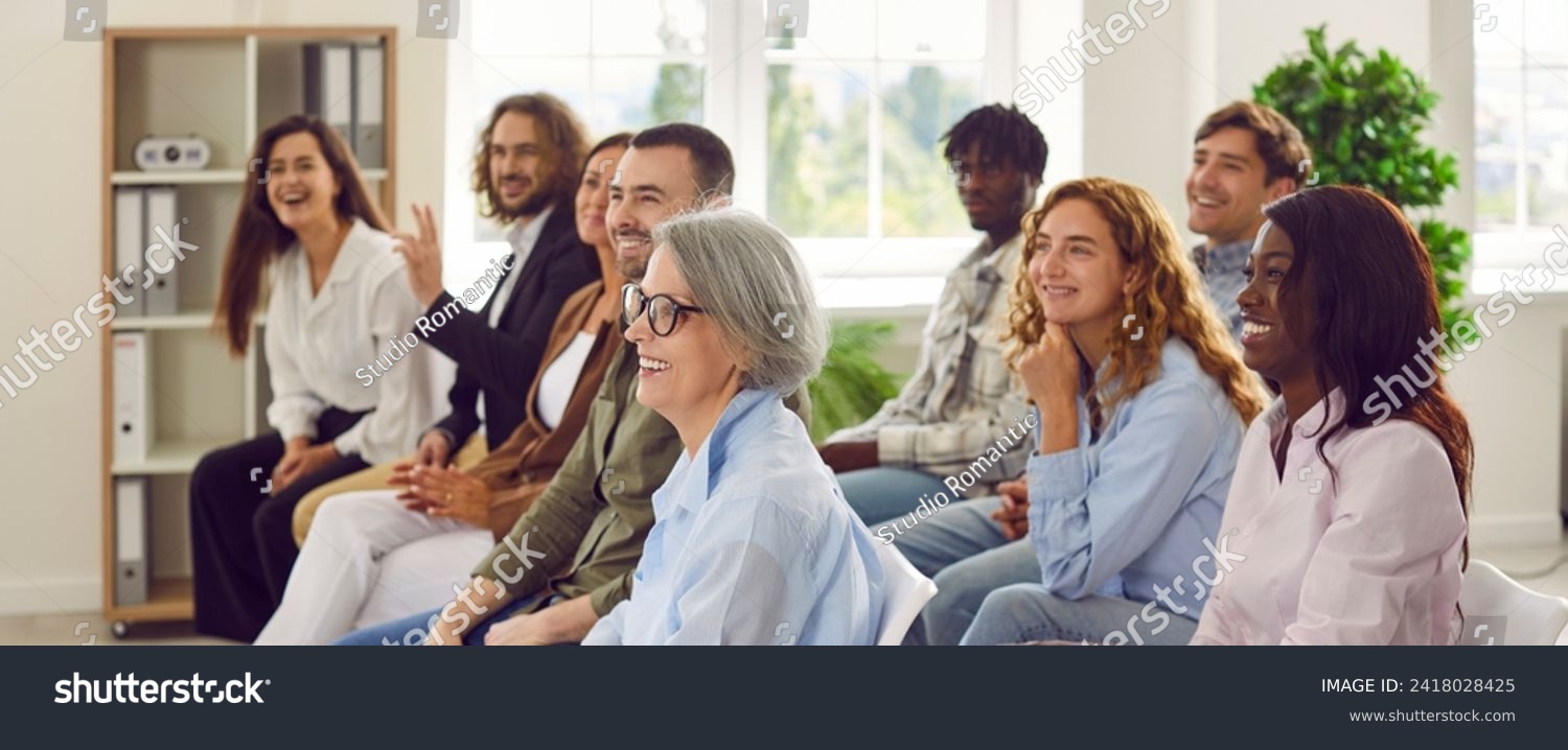 Candid happy diverse young senior female male businesspeople entrepreneur colleague audience at business forum event staff training listen to speech by successful coach making funny good humor jokes #2418028425