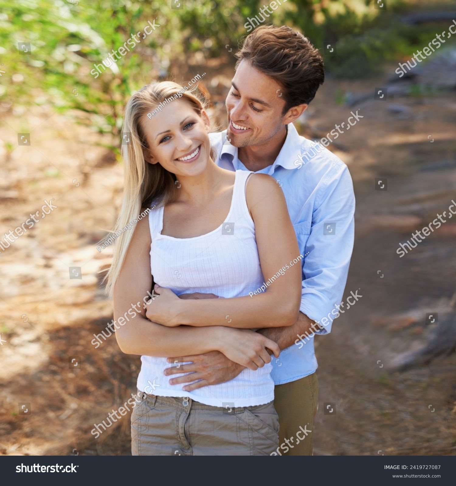 Nature portrait, love and happy couple hug for support, romantic care and relationship security with marriage partner. Embrace, wellness and relax outdoor man, woman or people smile for forest date #2419727087