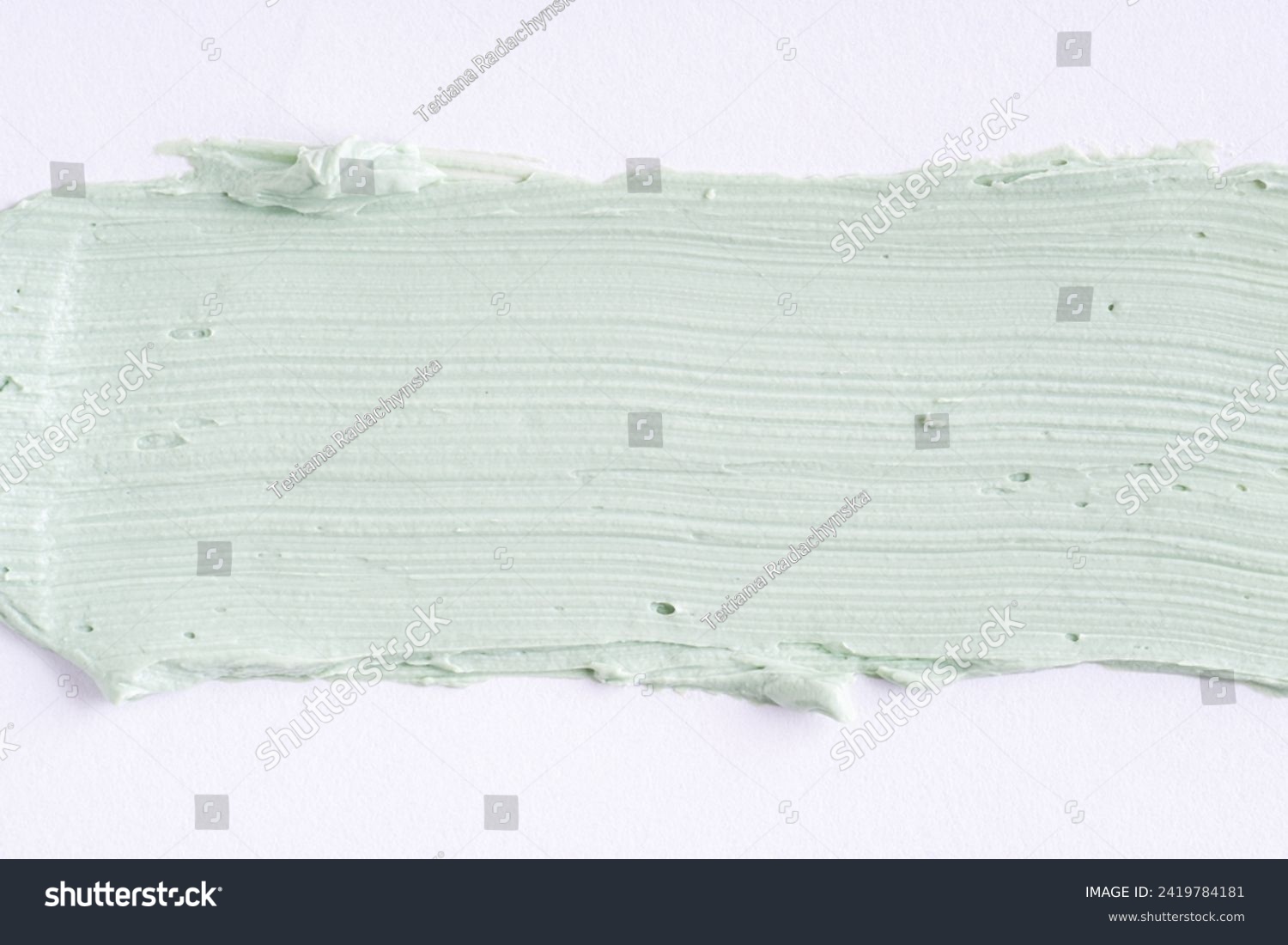 Green clay mask or correcting concealer smear smudge on white background. Cream texture. Facial mask, skincare beauty product swatch closeup. SPA background #2419784181
