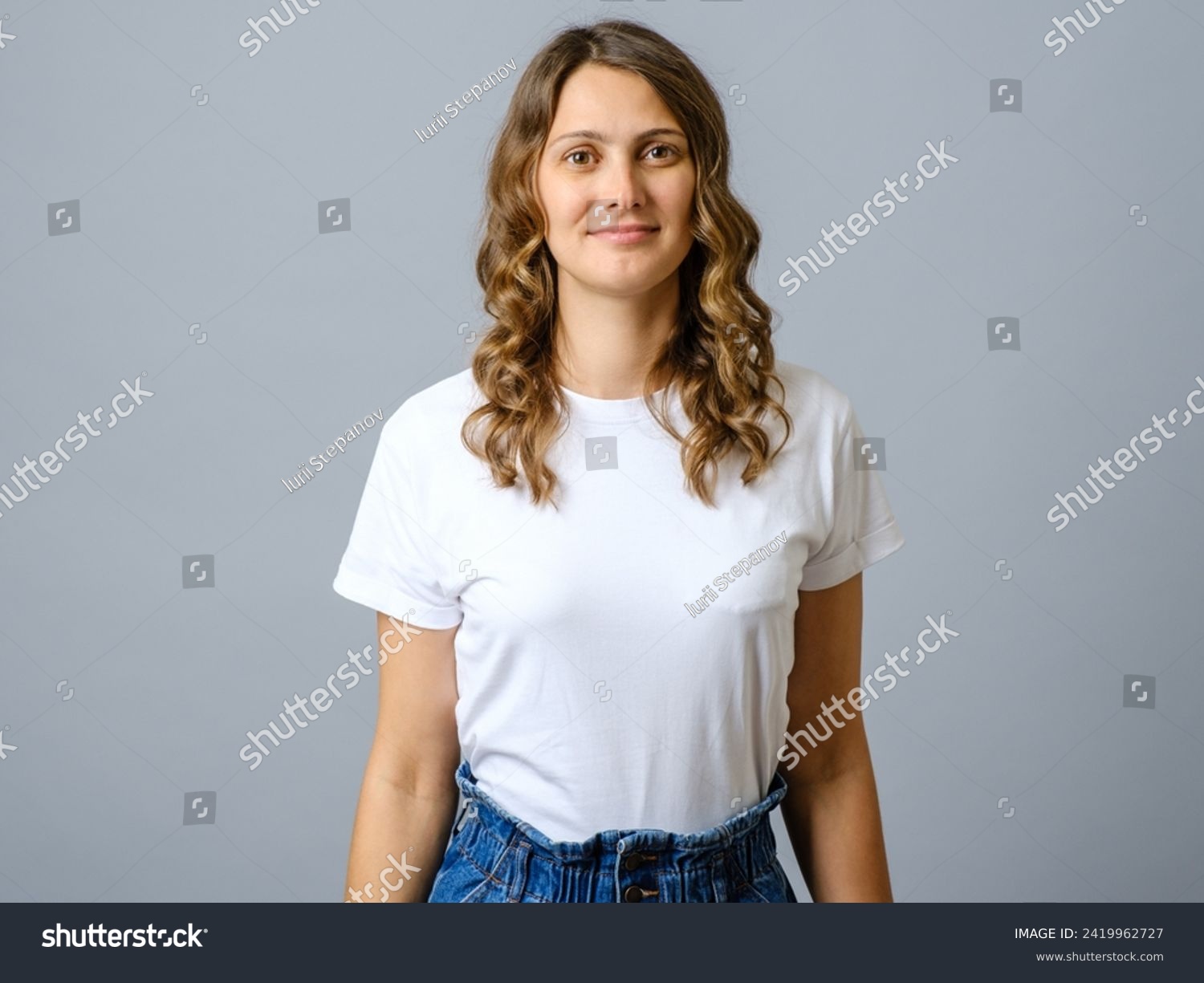 Happy successful woman in casual outfit smiling at camera and looking confident against gray background #2419962727