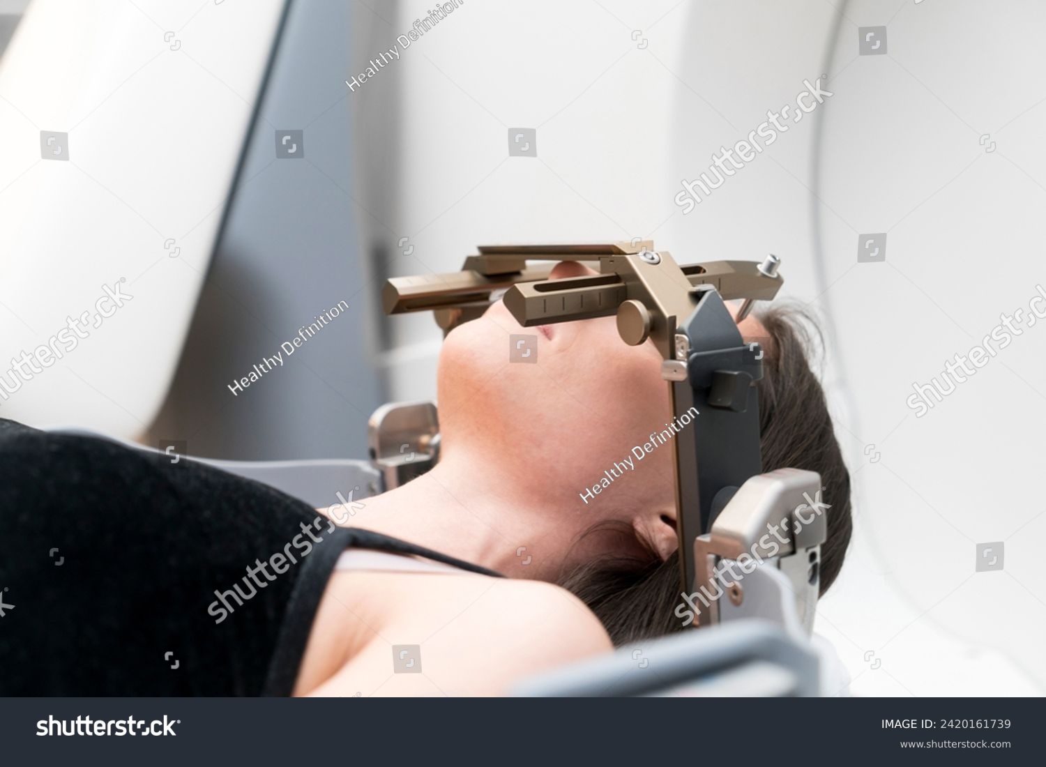 The patient lies in front of the device for the treatment of cancer with a gamma knife. She has a metal clip cap on his head. Gamma Knife stereotactic radiosurgery. #2420161739