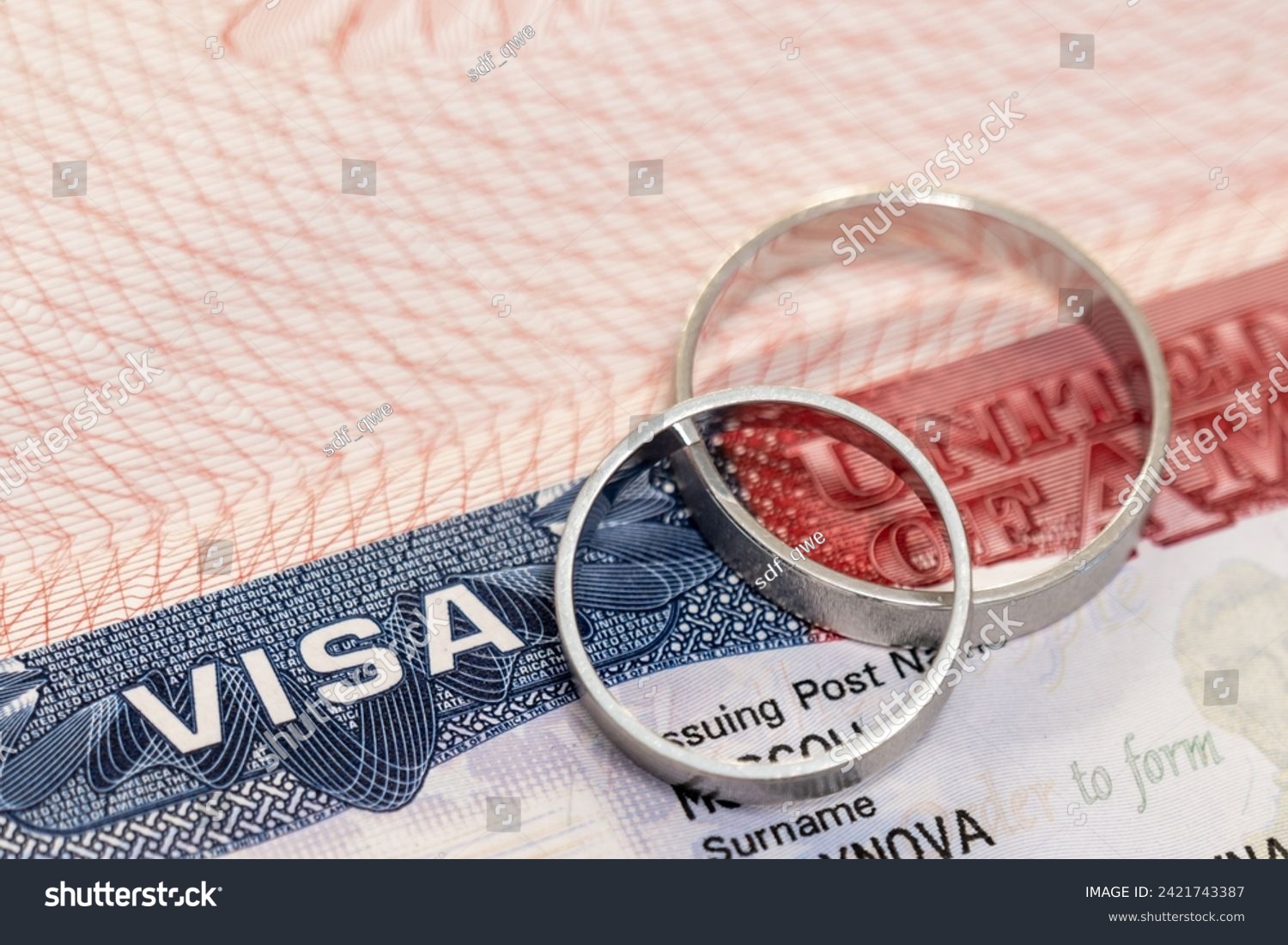 Wedding rings on passport with us visa as concept of marriage of convenience #2421743387