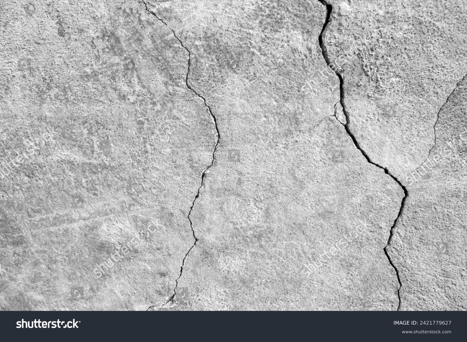 The wall of an old building with winding, deep cracks. Copy space. Black and white photo. Selective focus. #2421779627