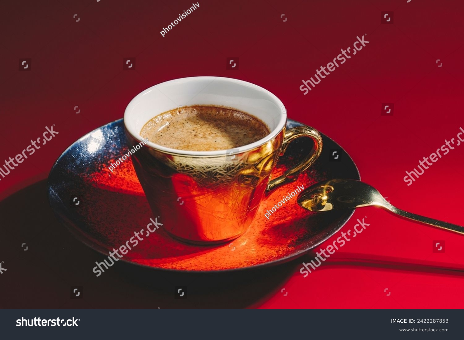 Coffee in a golden cup on a red background: A vibrant fusion, where the warm hues of the beverage harmonize with the bold red backdrop. #2422287853